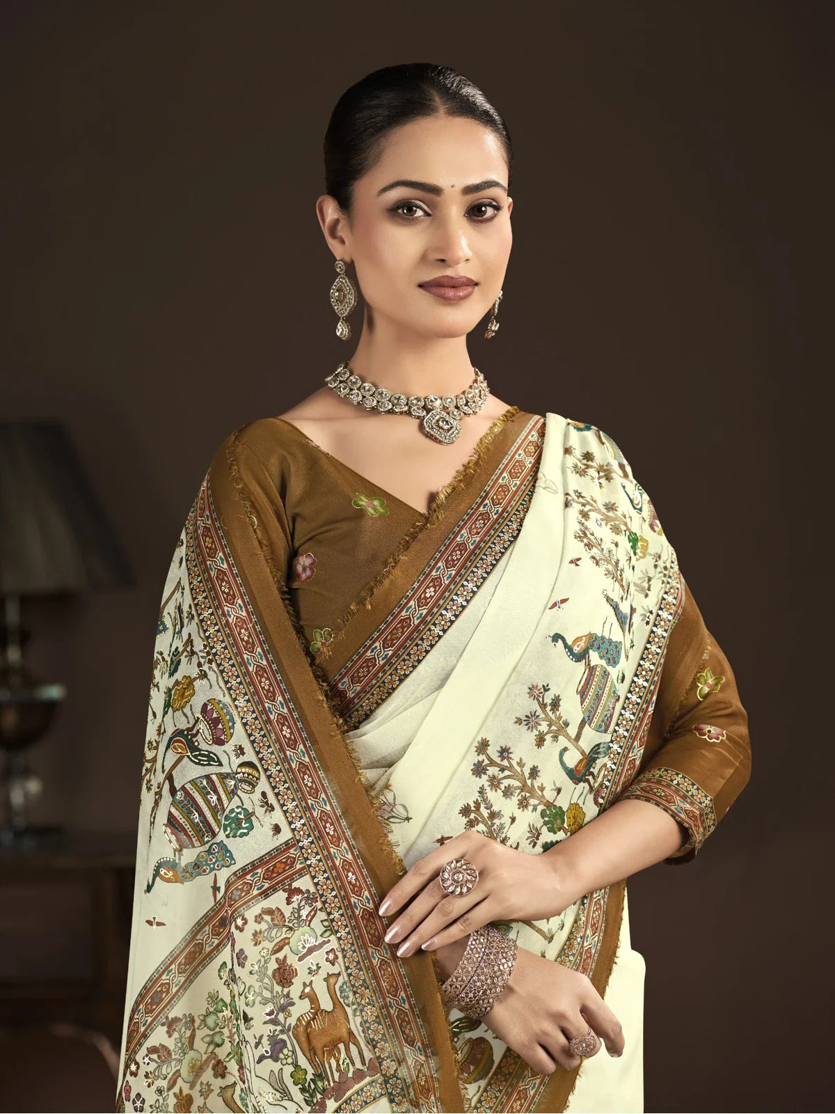 Tarani off white crepe silk saree with brown blouse and silver jewelry upper half model pose