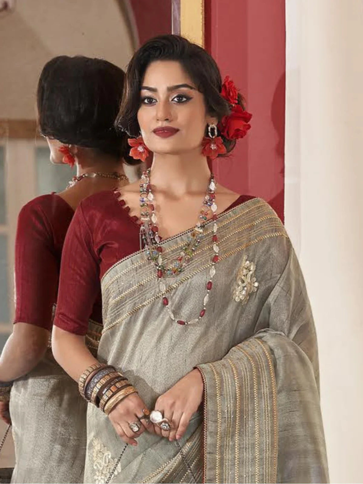 Tarani stylish grey fancy saree upper body view with maroon blouse and floral accessories