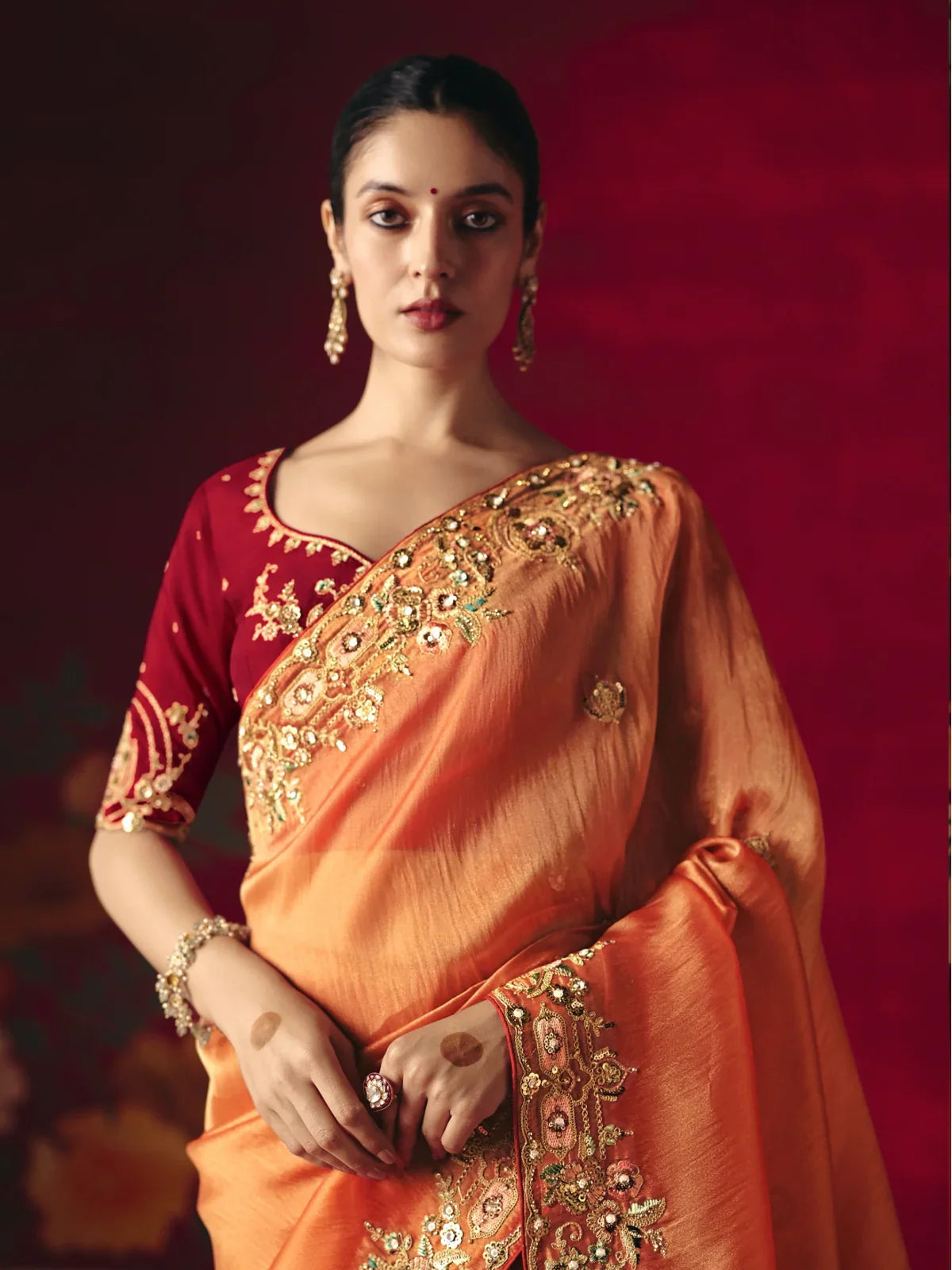 Tarani premium orange saree showing upper body with maroon embroidered blouse for festive occasions