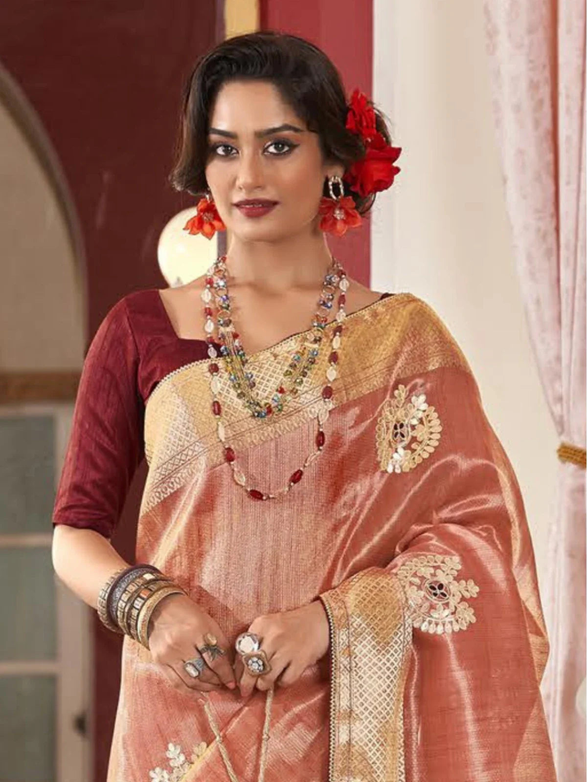 Tarani peach fancy saree upper body closeup showing elegant golden detailing