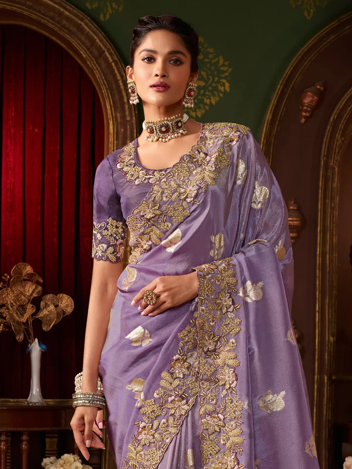Tarani purple party wear saree with floral blouse and rich embroidery shown in upper body pose