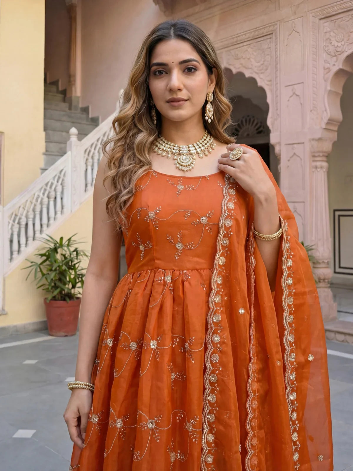 Tarani orange sleeveless embroidered dress closeup upper body view with necklace set