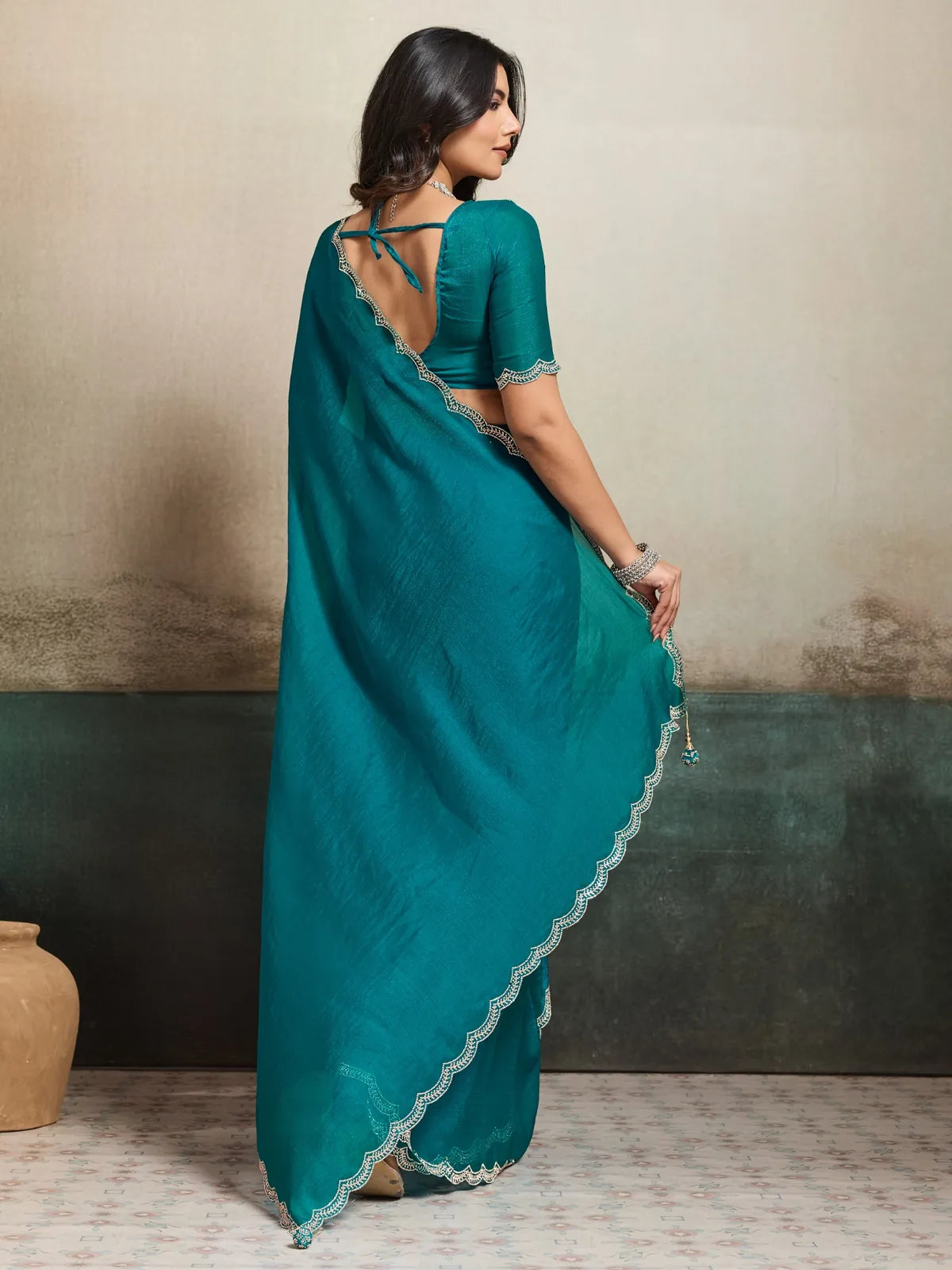 Tarani teal saree back view showcasing blouse back design and flowing pallu