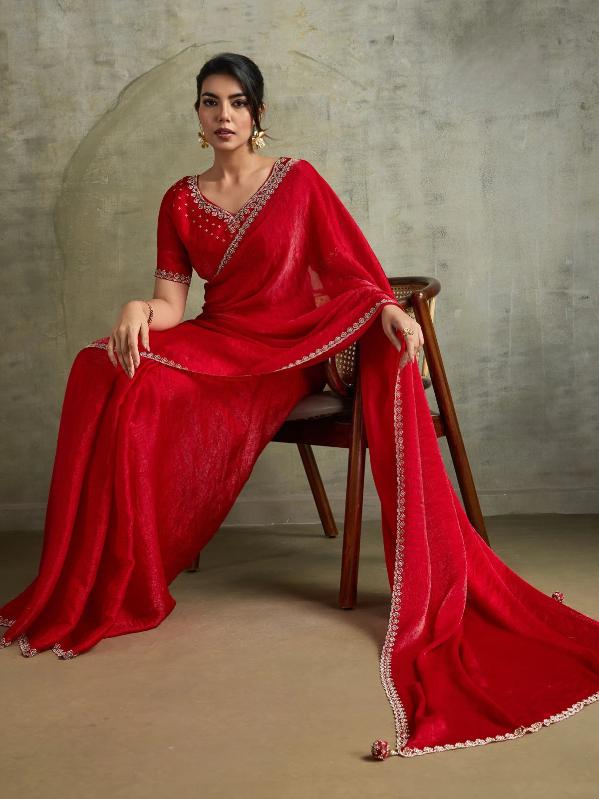 Tarani red party wear saree front pose with shimmering Zarkan work and flowing pallu