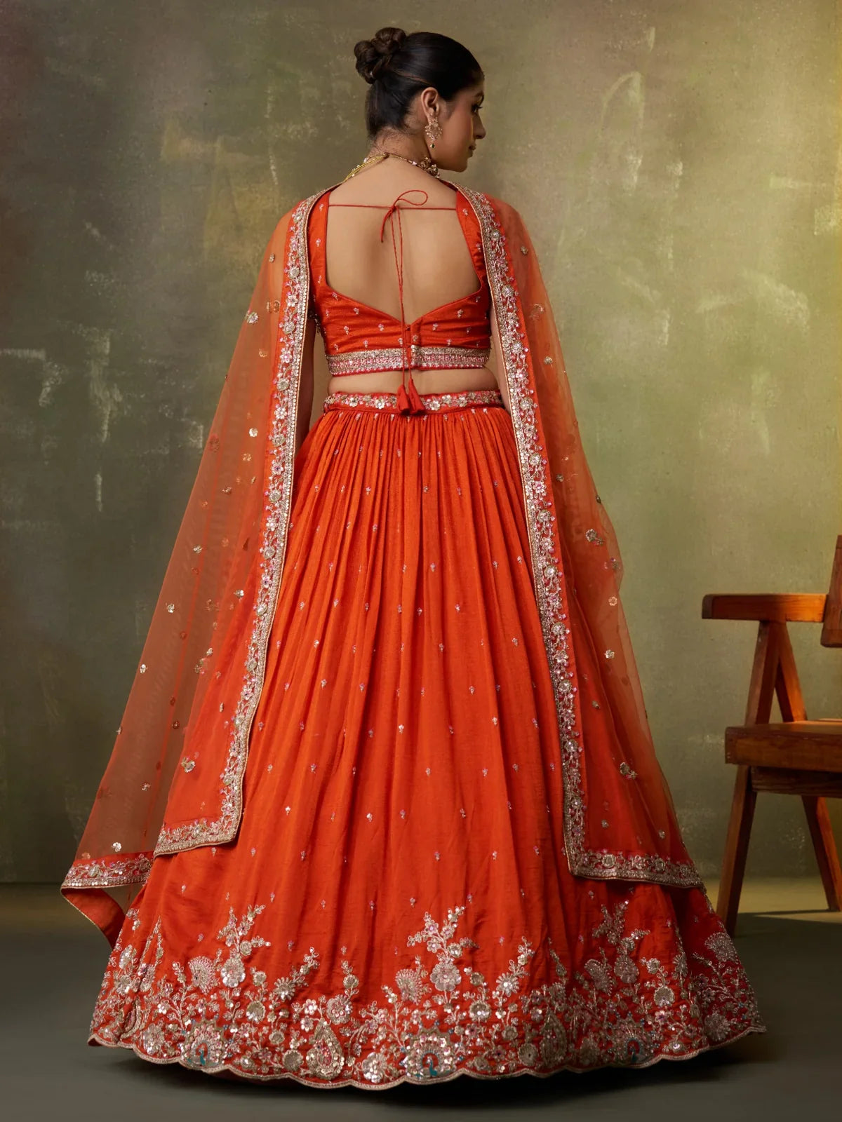 Tarani back view of orange georgette lehenga with tied blouse and heavy flare