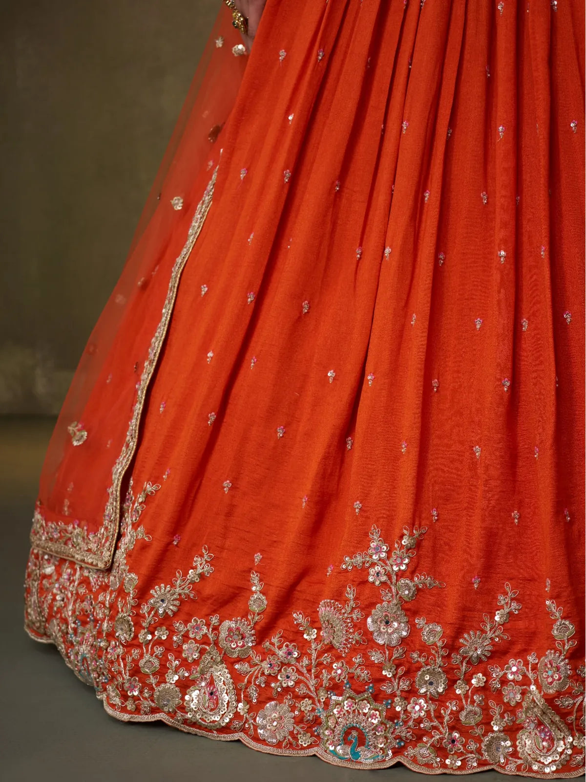 Tarani close-up detailing of hemline embroidery on orange georgette lehenga skirt