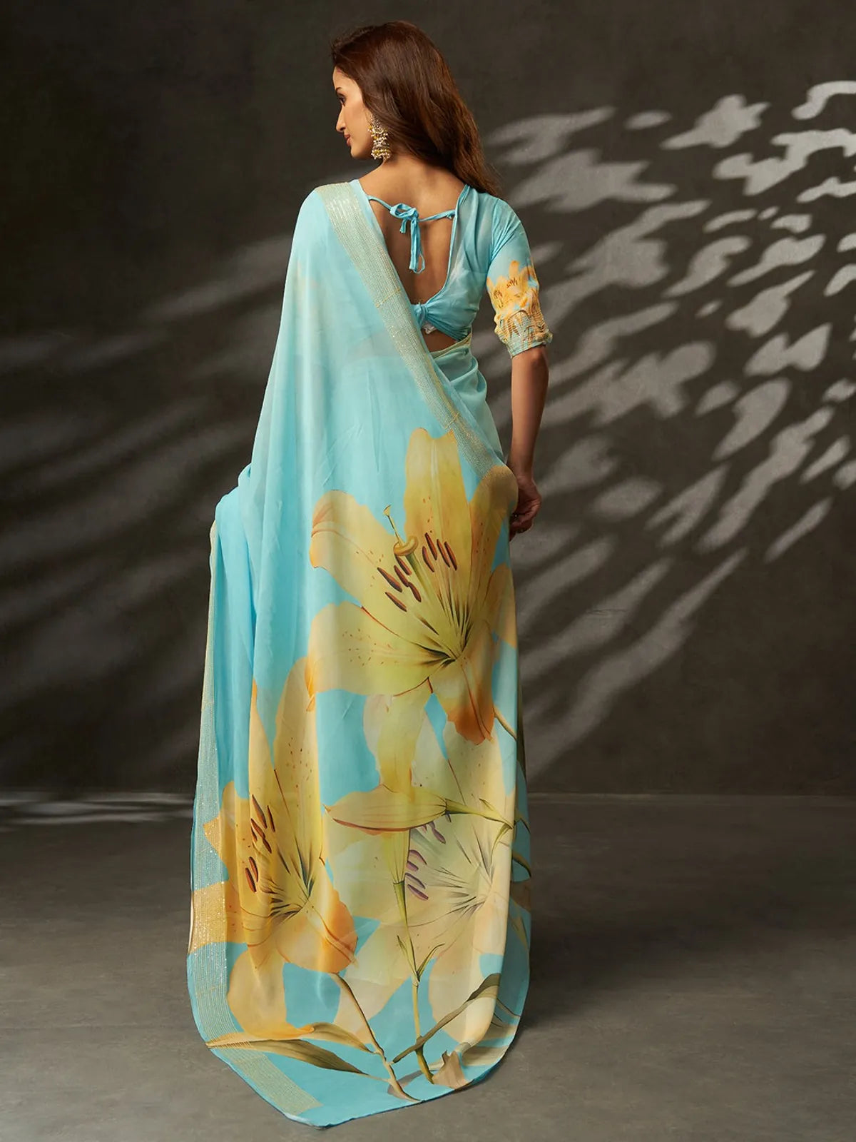 Tarani premium blue georgette saree back view with yellow floral design and matching blouse