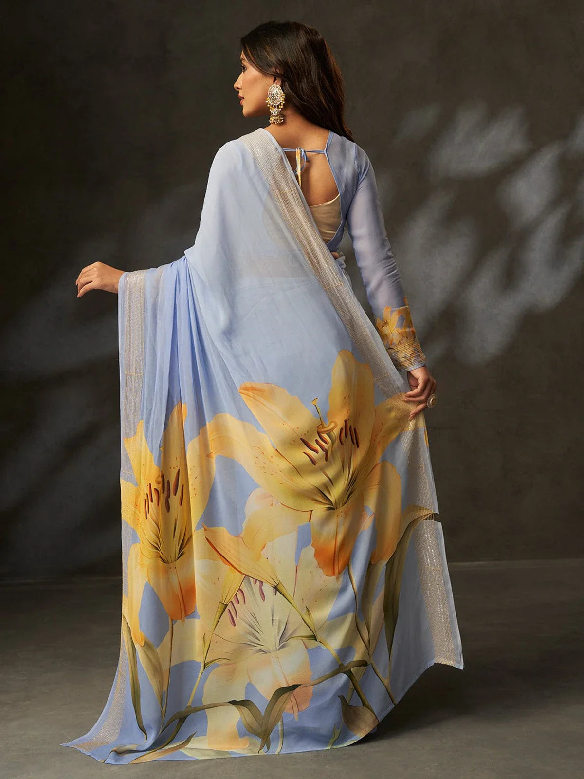 Tarani back view of sky blue saree with oversized yellow floral art and delicate fall