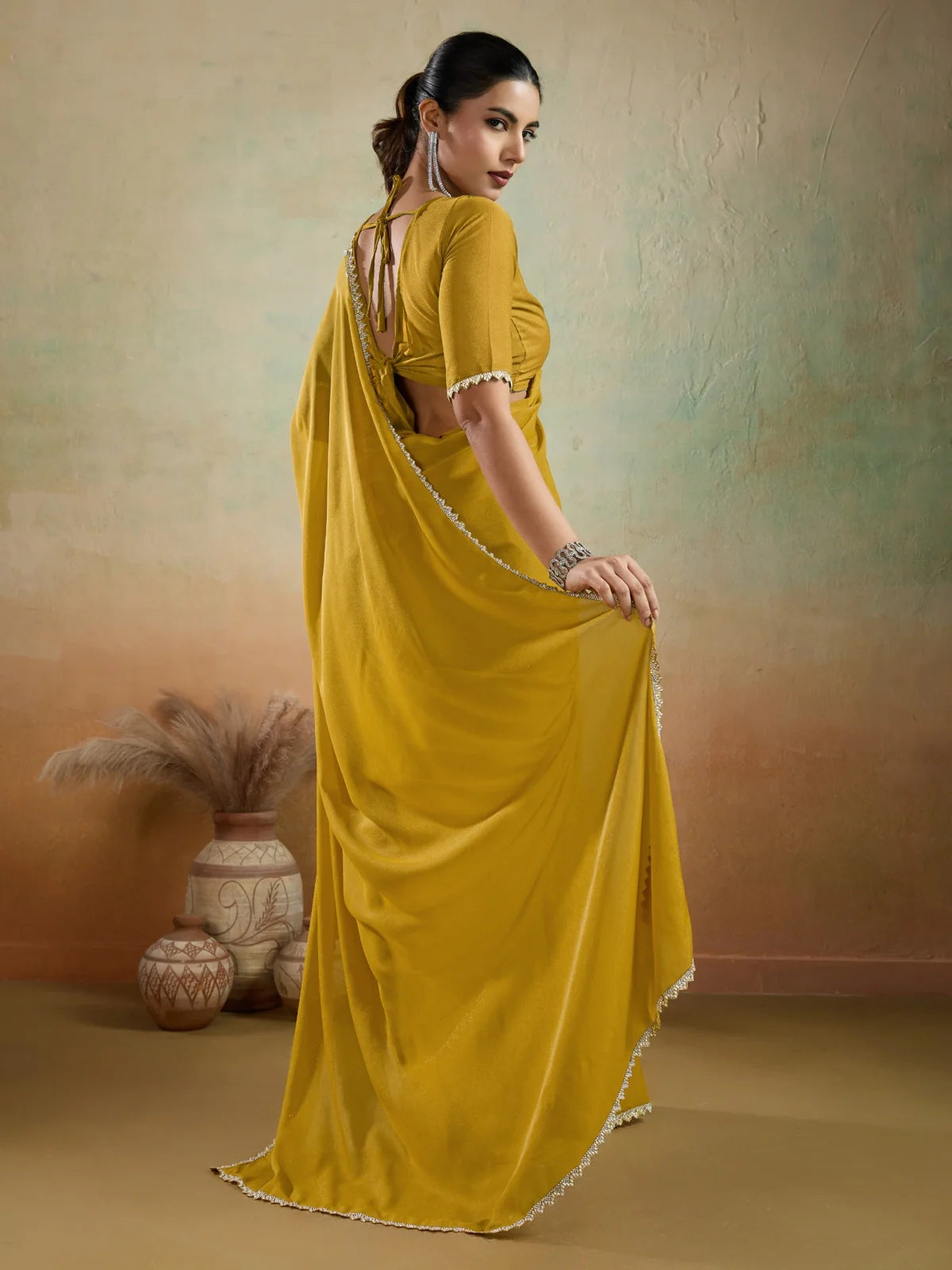 Tarani mustard georgette saree with lace border highlighted in back view