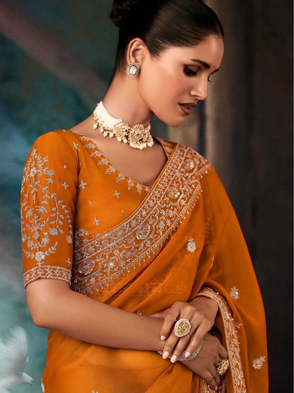 Tarani georgette saree in orange featuring elegant neckline and blouse embroidery