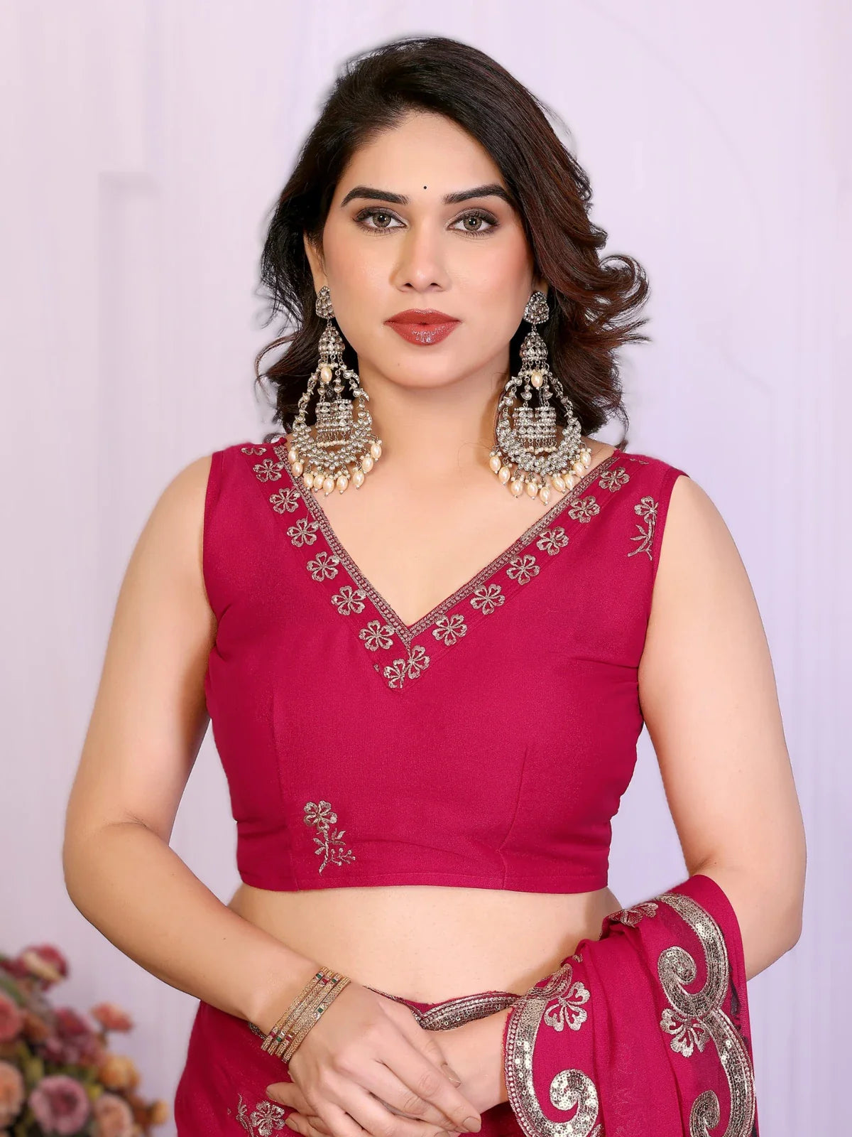 Tarani upper body view of pink georgette saree blouse with neckline embroidery and sleeveless cut
