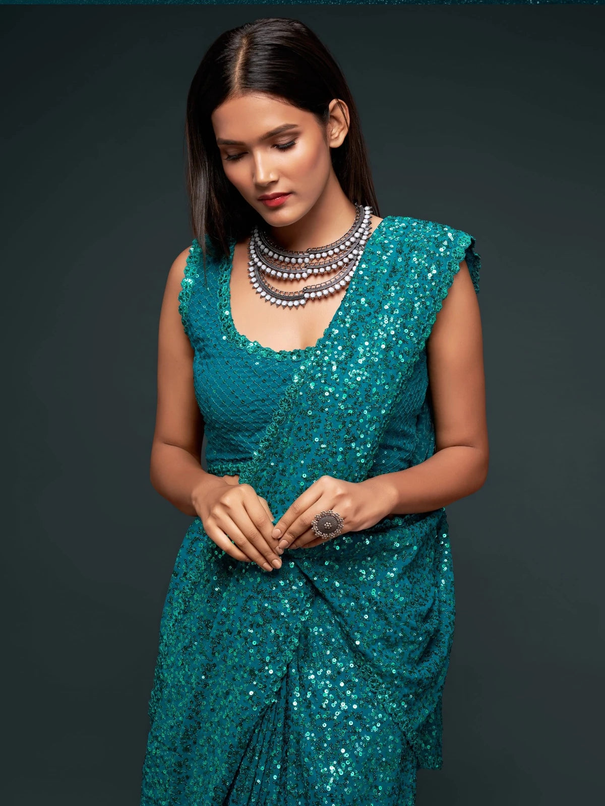 Tarani teal georgette saree upper body view with embroidered blouse and sequins detailing