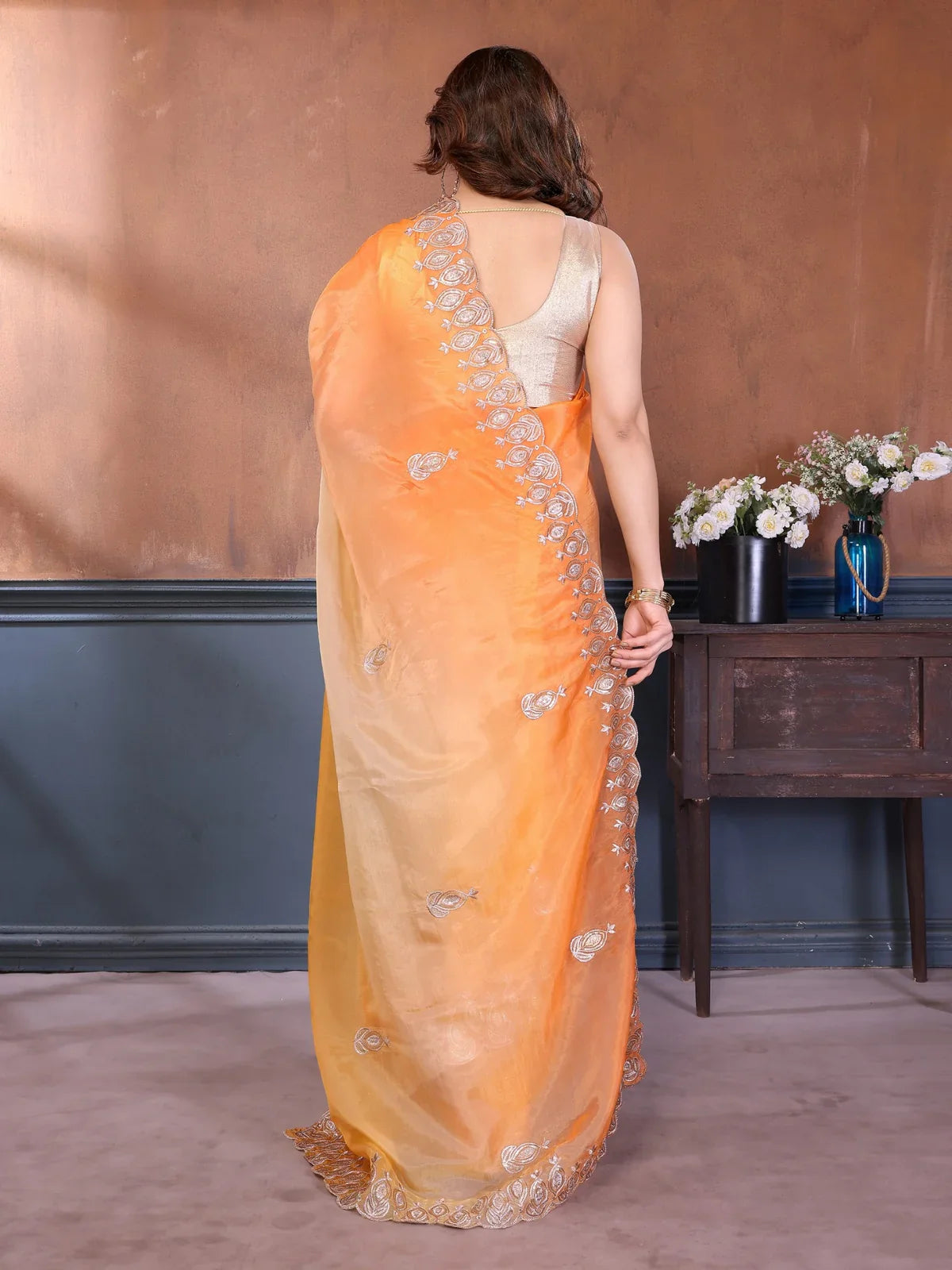 Tarani full back drape view of orange saree in soft shimmer with embroidered edge and stylish blouse