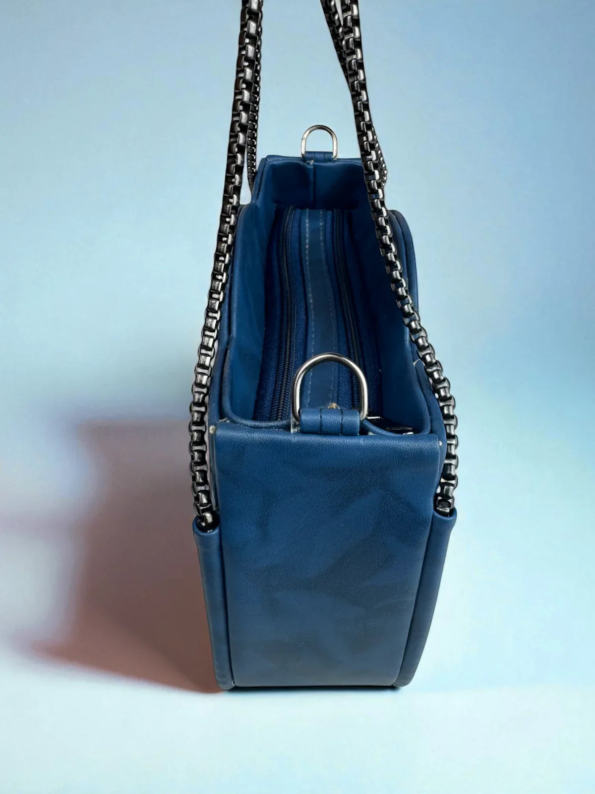 Tarani blue PU leather handbag side view with chain strap and zipper