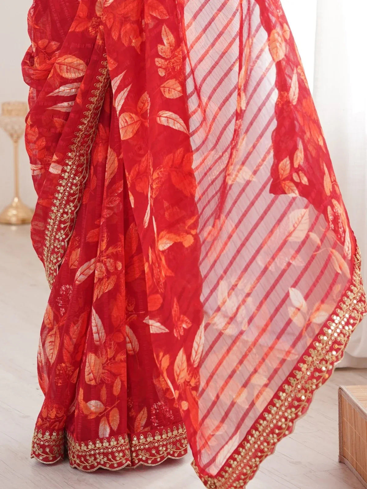 Tarani red saree pallu closeup with soft leaf motifs and gold work