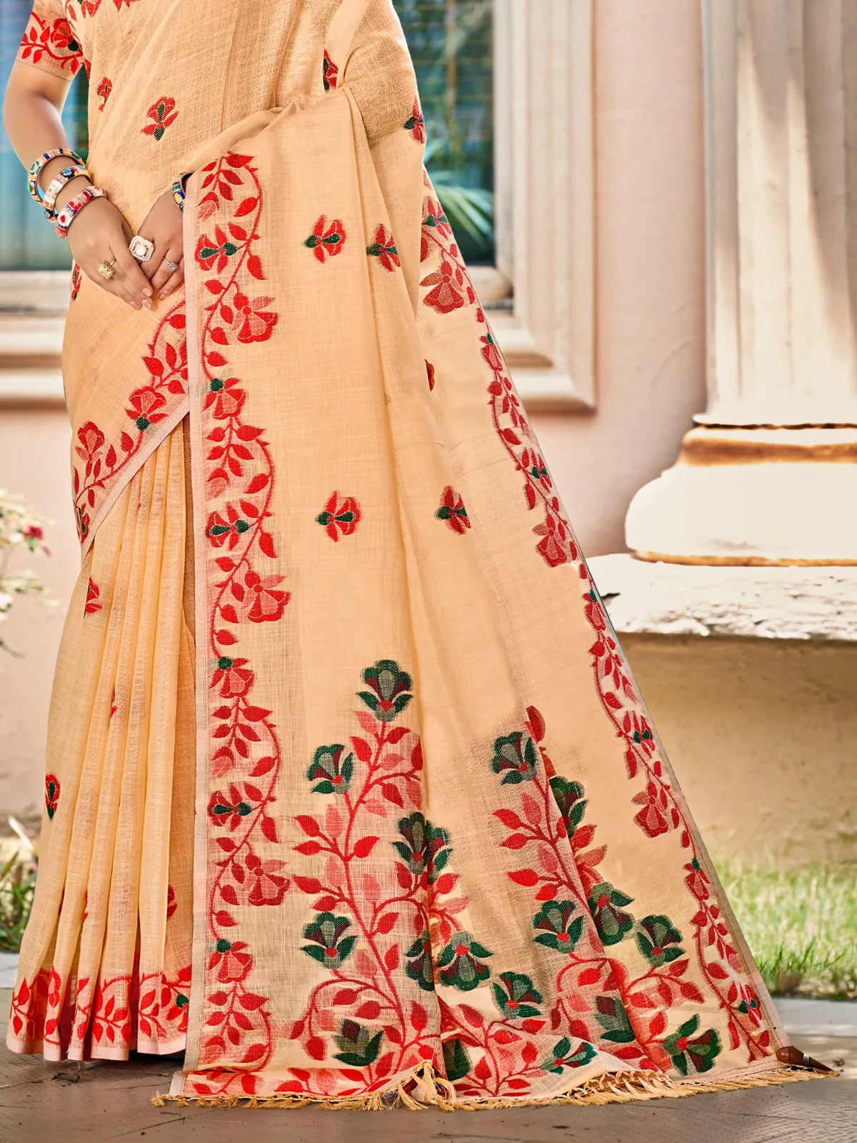 Tarani peach Lilen saree pallu view with intricate red and green floral embroidery