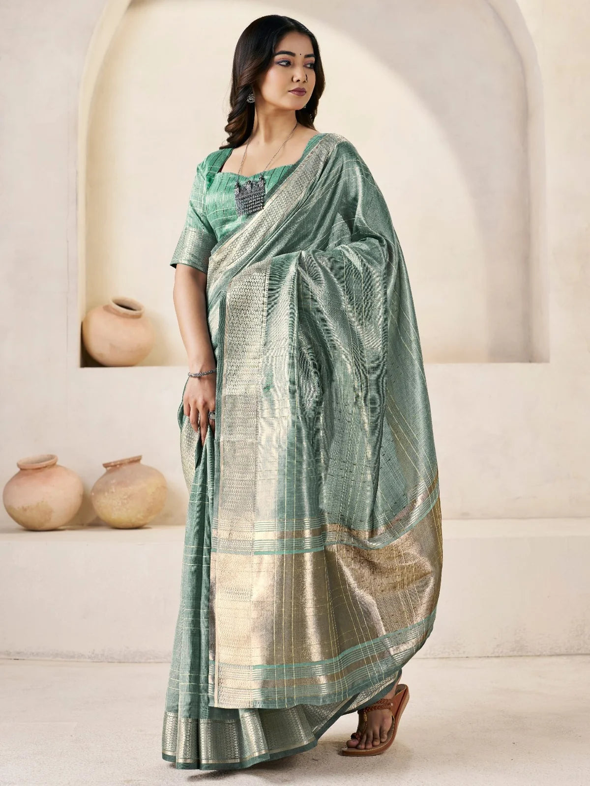 Tarani sea green linen cotton silk saree side pose highlighting zari pallu and elegant drape