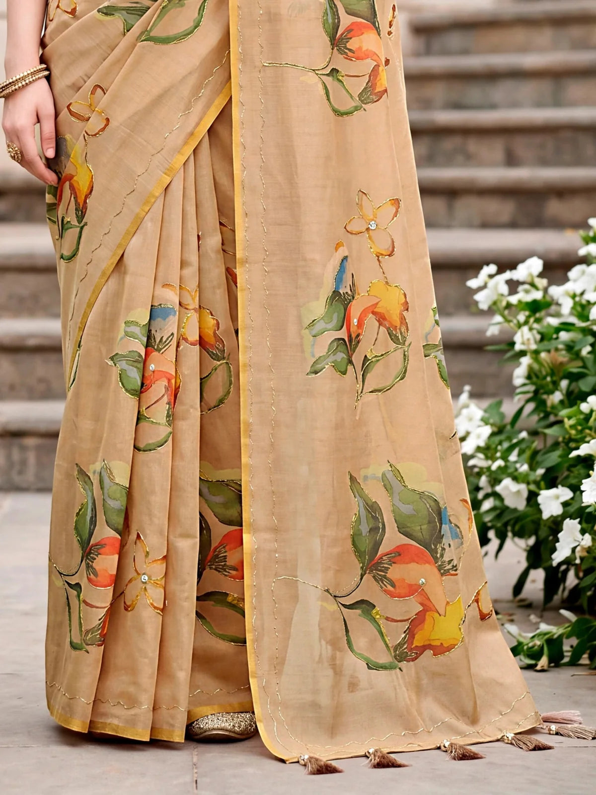 Tarani Phalguni beige linen cotton saree pallu view with floral motifs tassels and intricate Aari work details