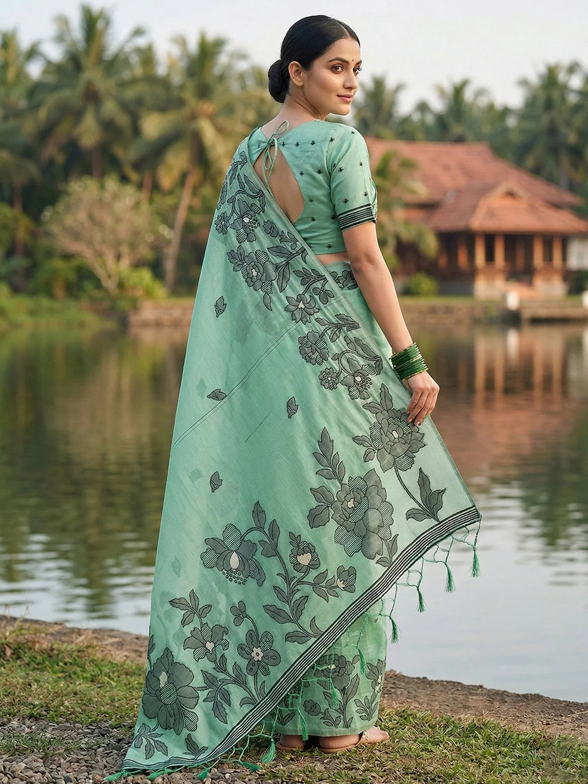 Tarani mint green linen cotton printed saree back view with floral border and tassel pallu