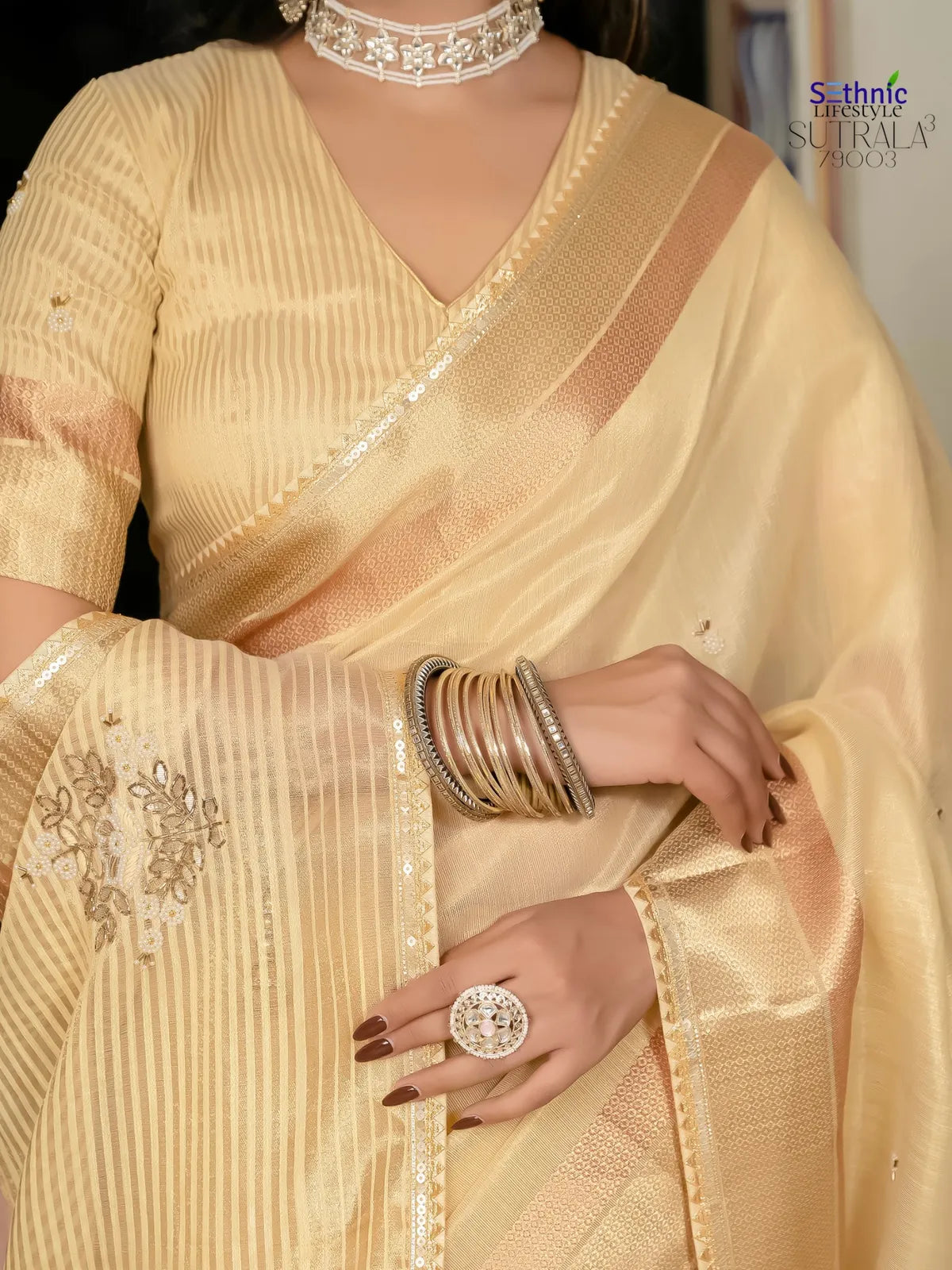 Tarani closeup of beige tissue linen saree showing zari patta and floral khatli embroidery