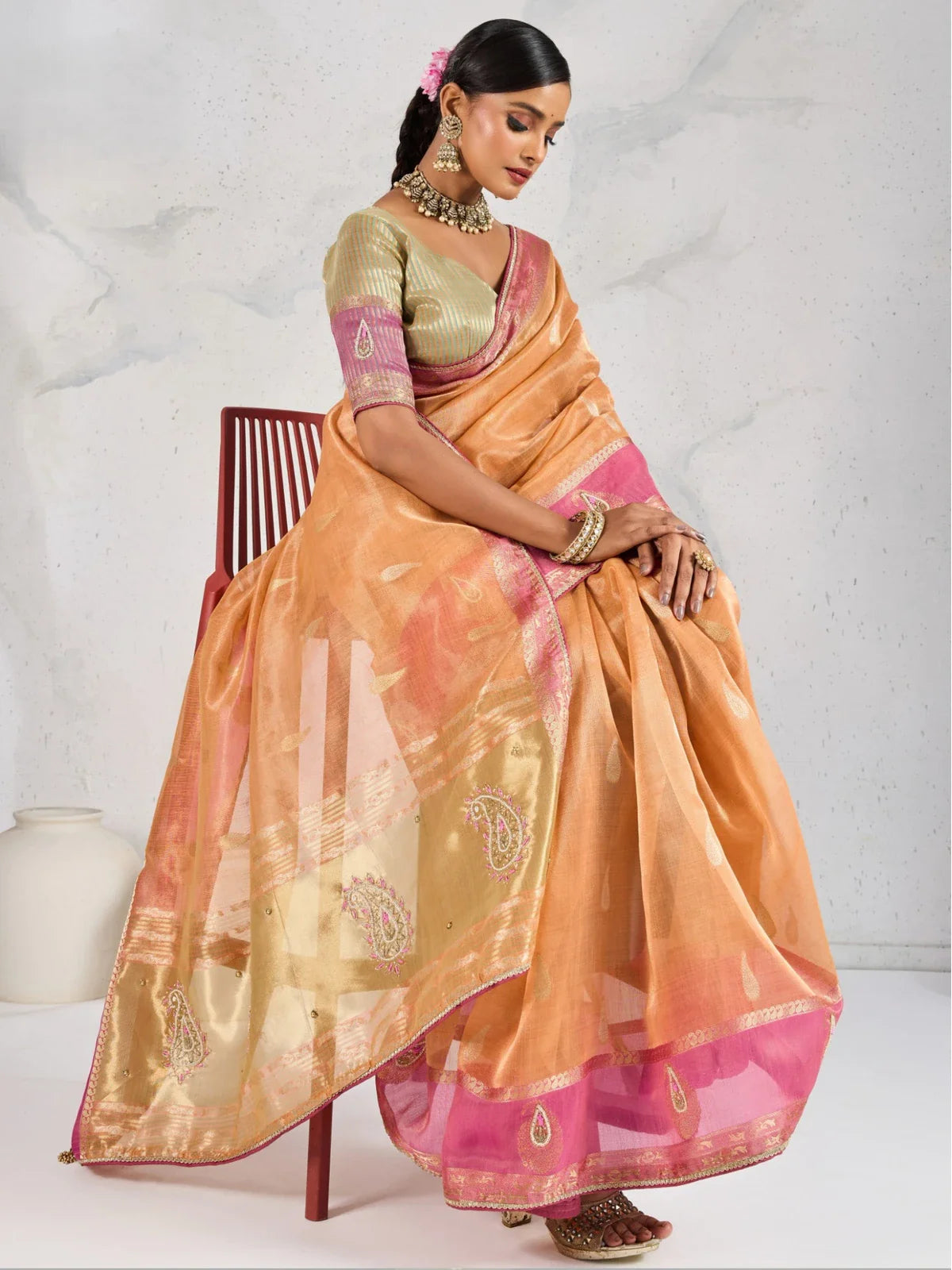 Tarani stylish orange linen saree back view showing zari woven pallu and contrast blouse