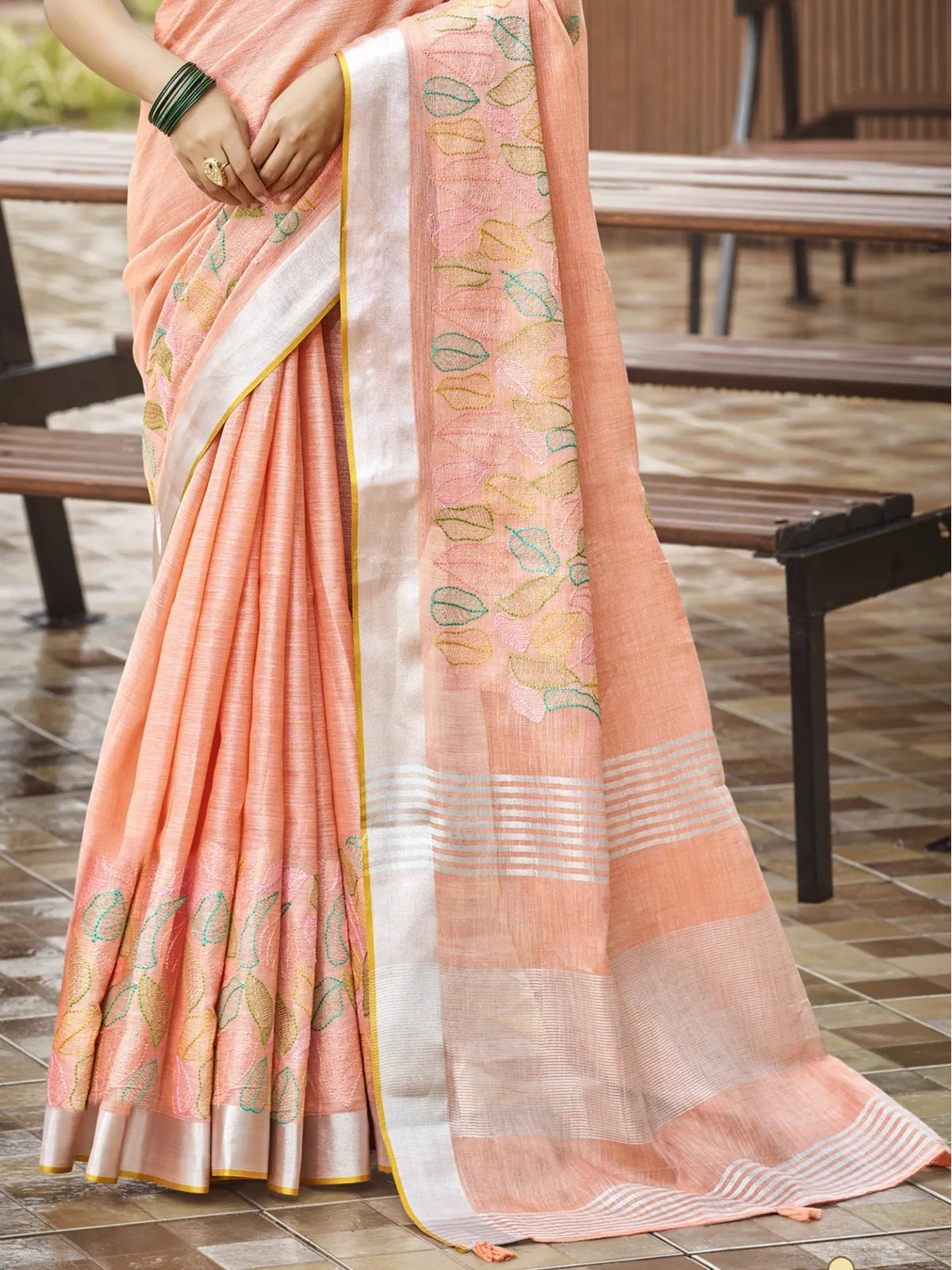 Tarani peach linen saree pallu view highlighting woven leaf designs and soft drape