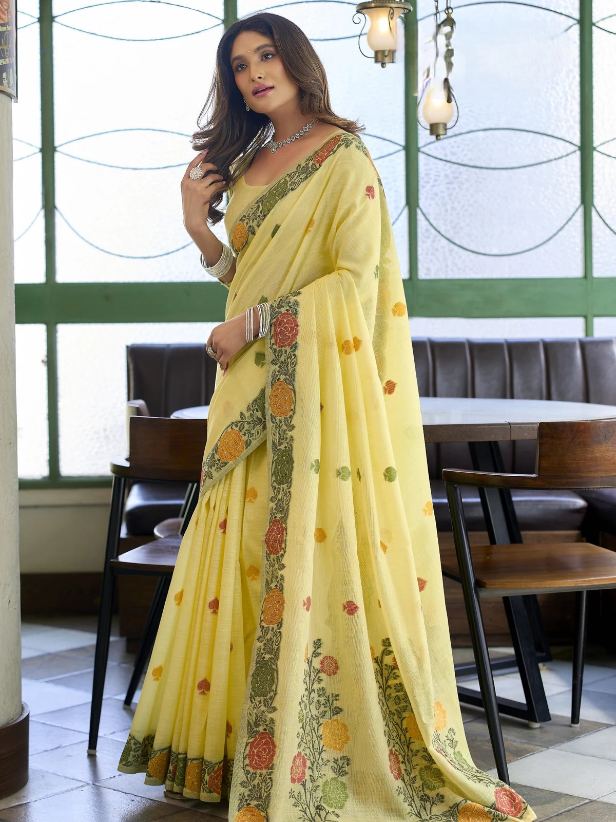 Tarani yellow festive linen saree side view with floral woven border and graceful drape