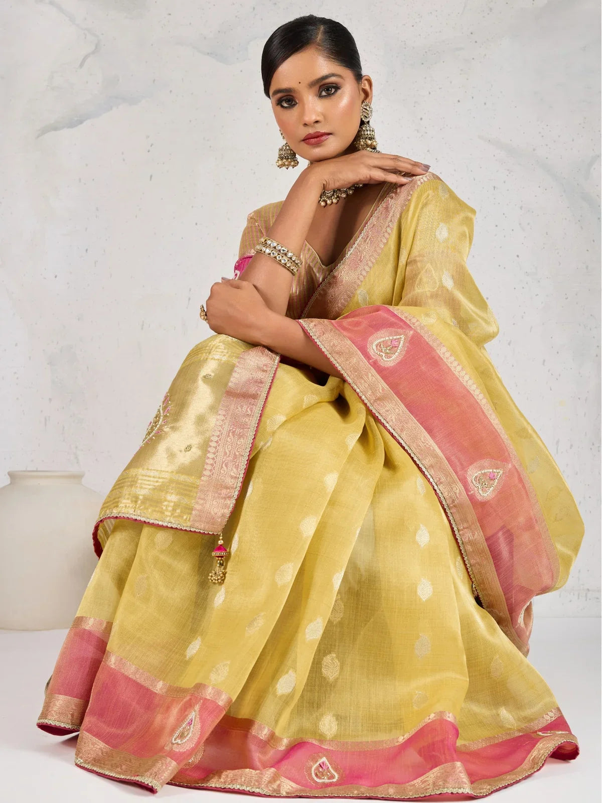Tarani yellow linen saree side pose with pink border and woven design