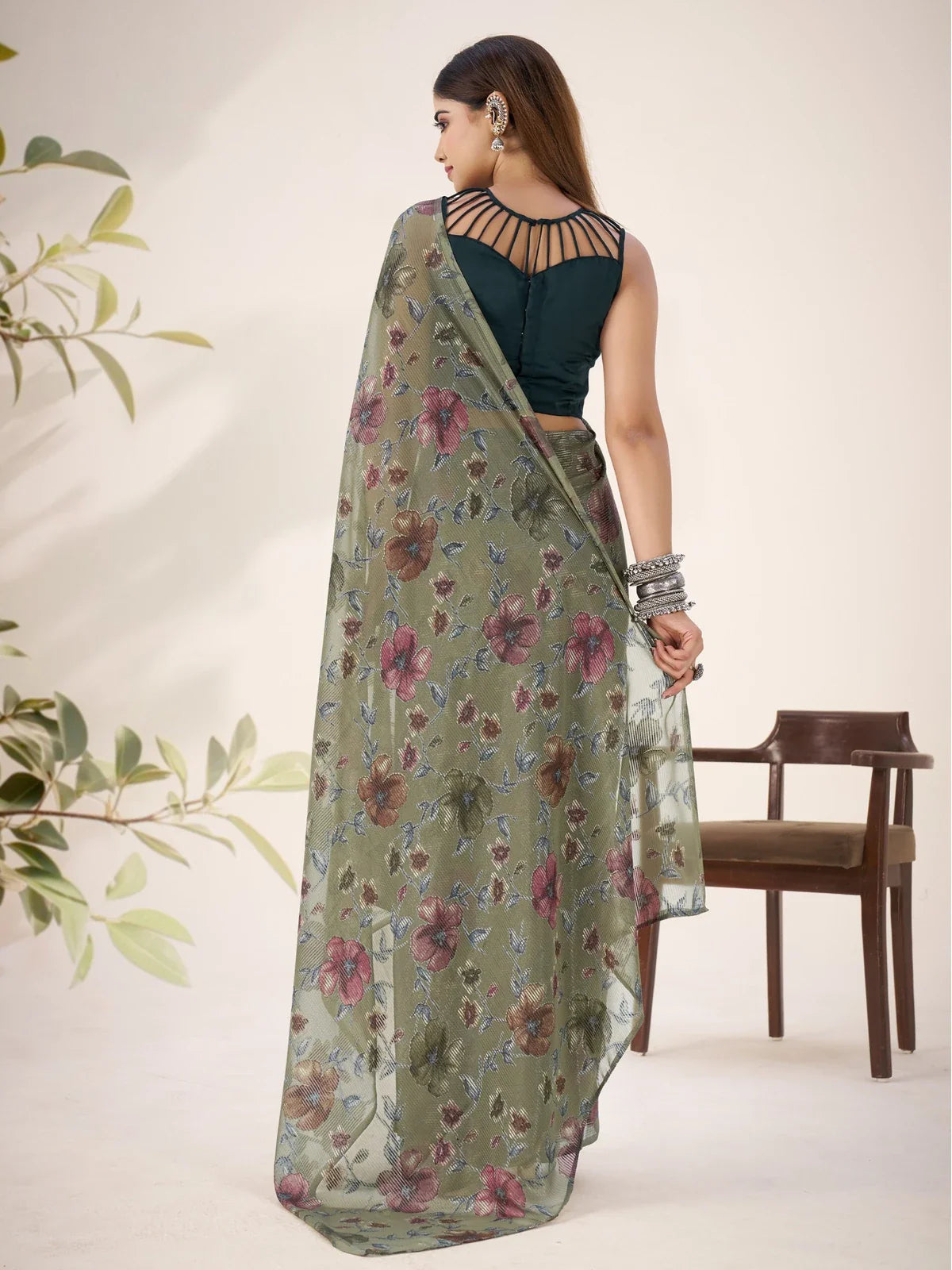 Tarani back view showing pallu fall of green brasso saree with soft floral pattern for women