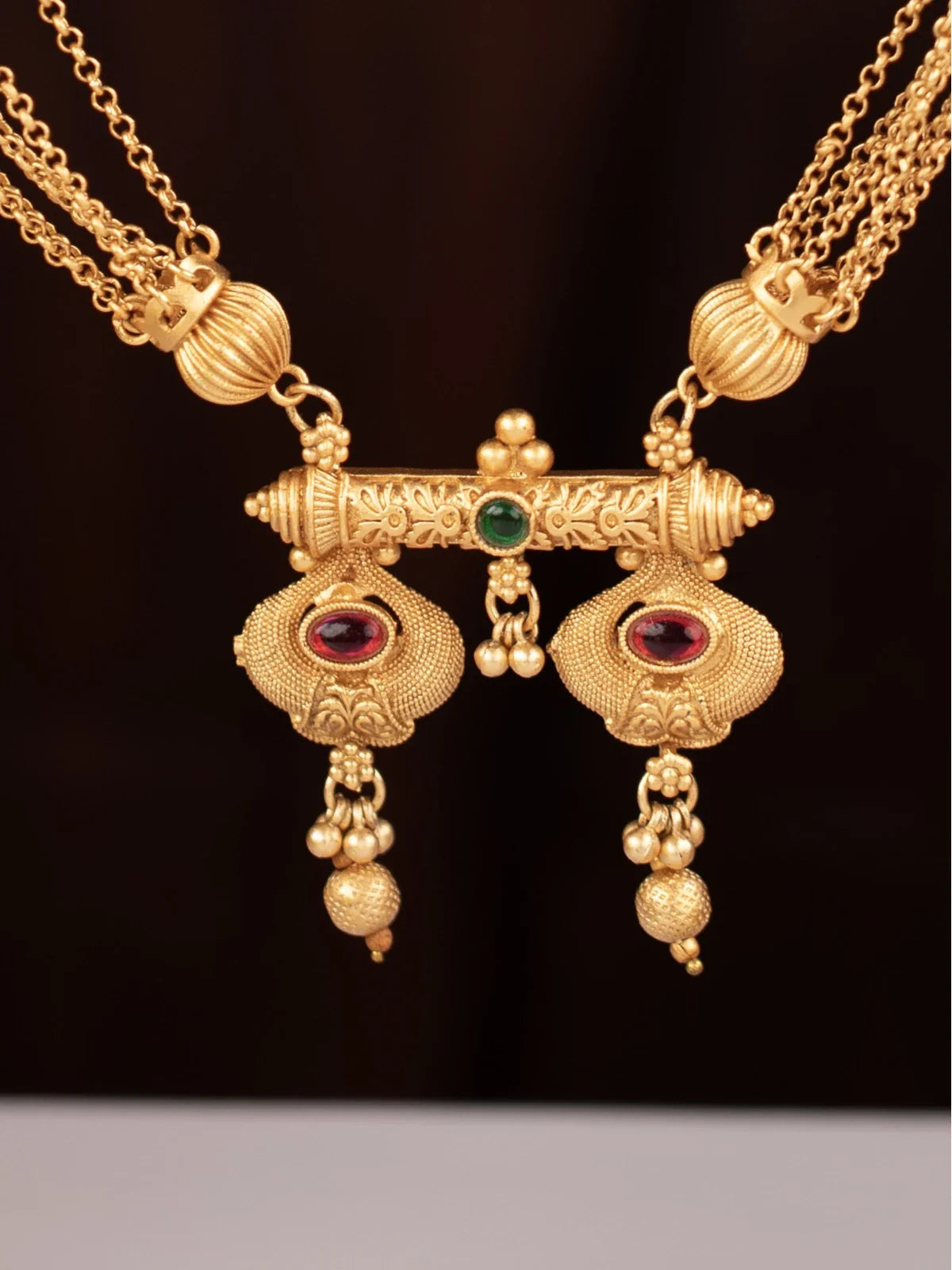 Tarani closeup view of gold plated mangalsutra pendant with stone detailing