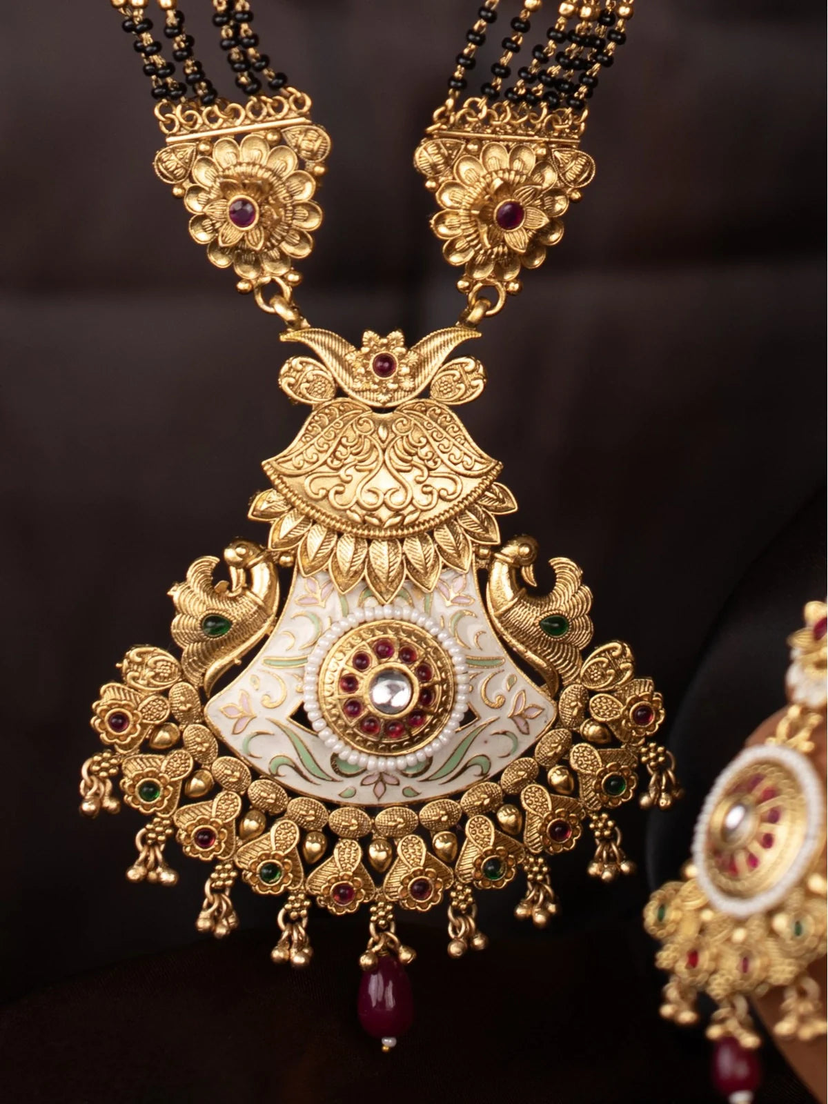 Tarani closeup view of gold plated meenakari mangalsutra pendant with stone detailing