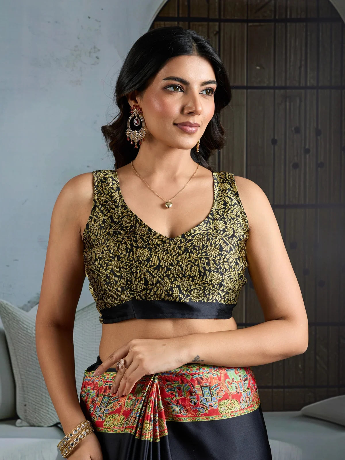 Tarani black blouse in golden floral design paired with modal satin saree for festive wear