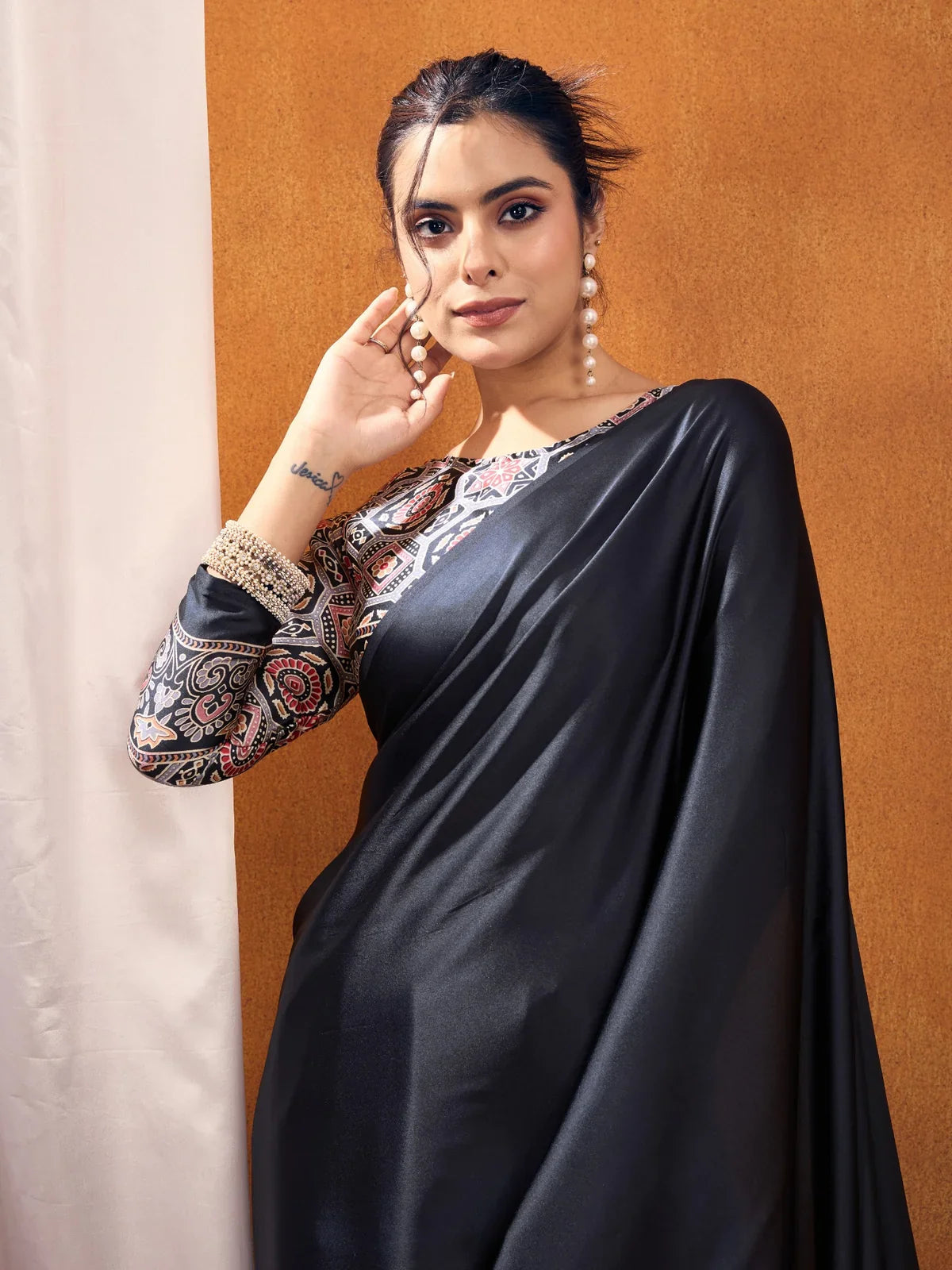 Tarani black modal satin saree upper body with ajrakh blouse and pearl earrings