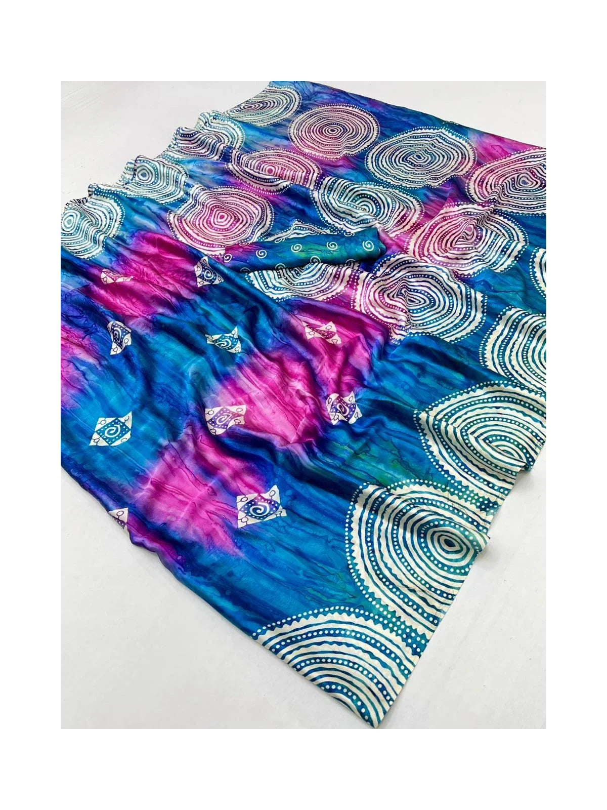Tarani modal satin saree fabric closeup with swirling print and blouse piece folded in view