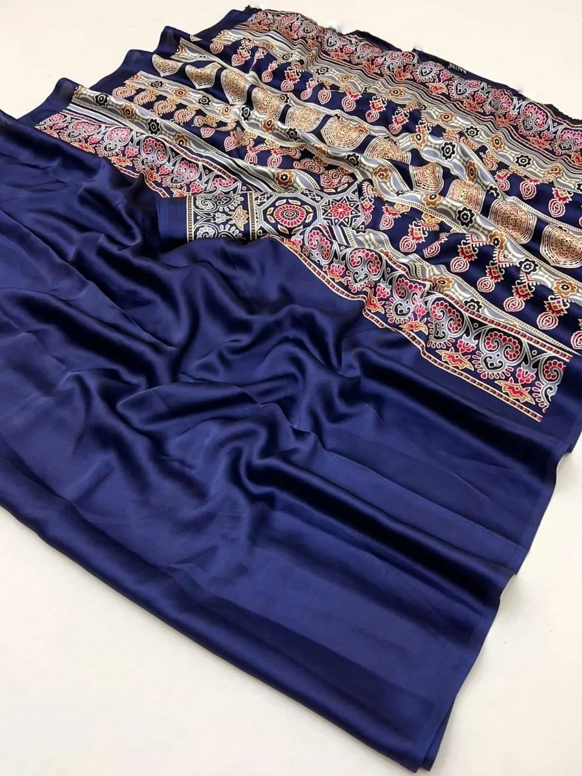 Tarani modal satin saree fabric closeup showing navy body and multicolor ajrakh pallu pattern