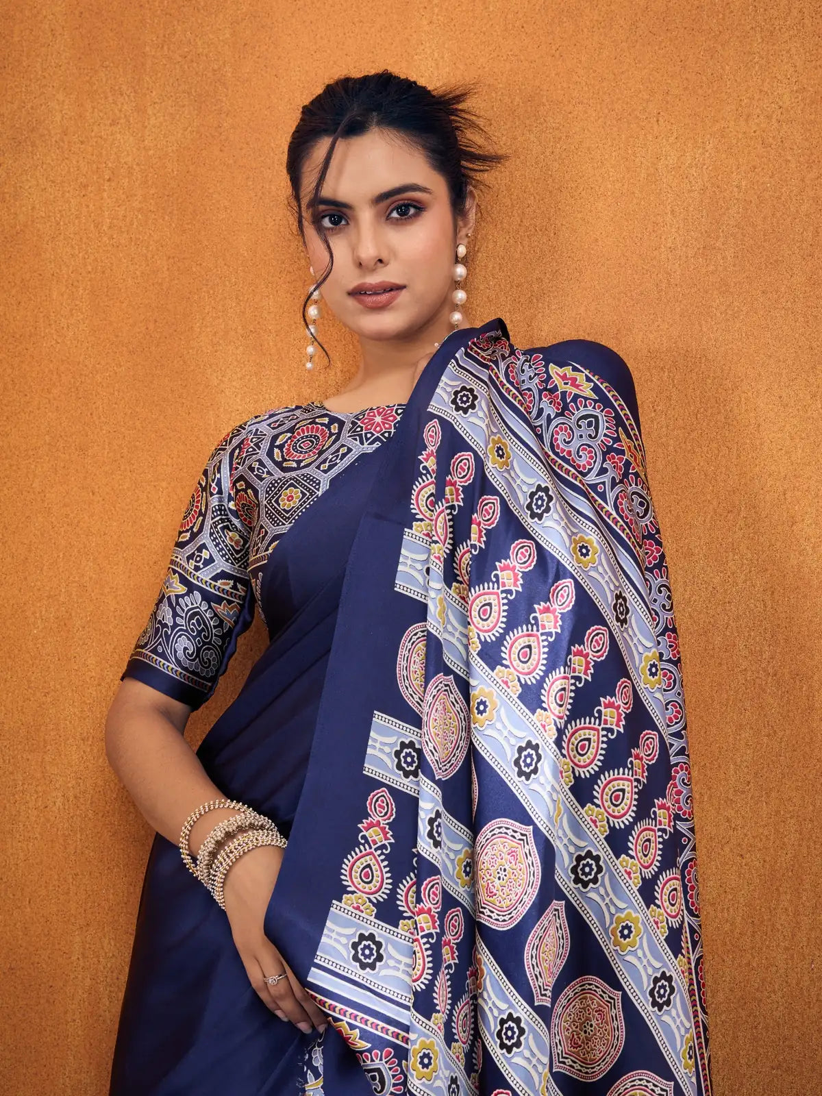 Tarani navy modal satin saree upper body view with multicolor blouse and pearl earrings