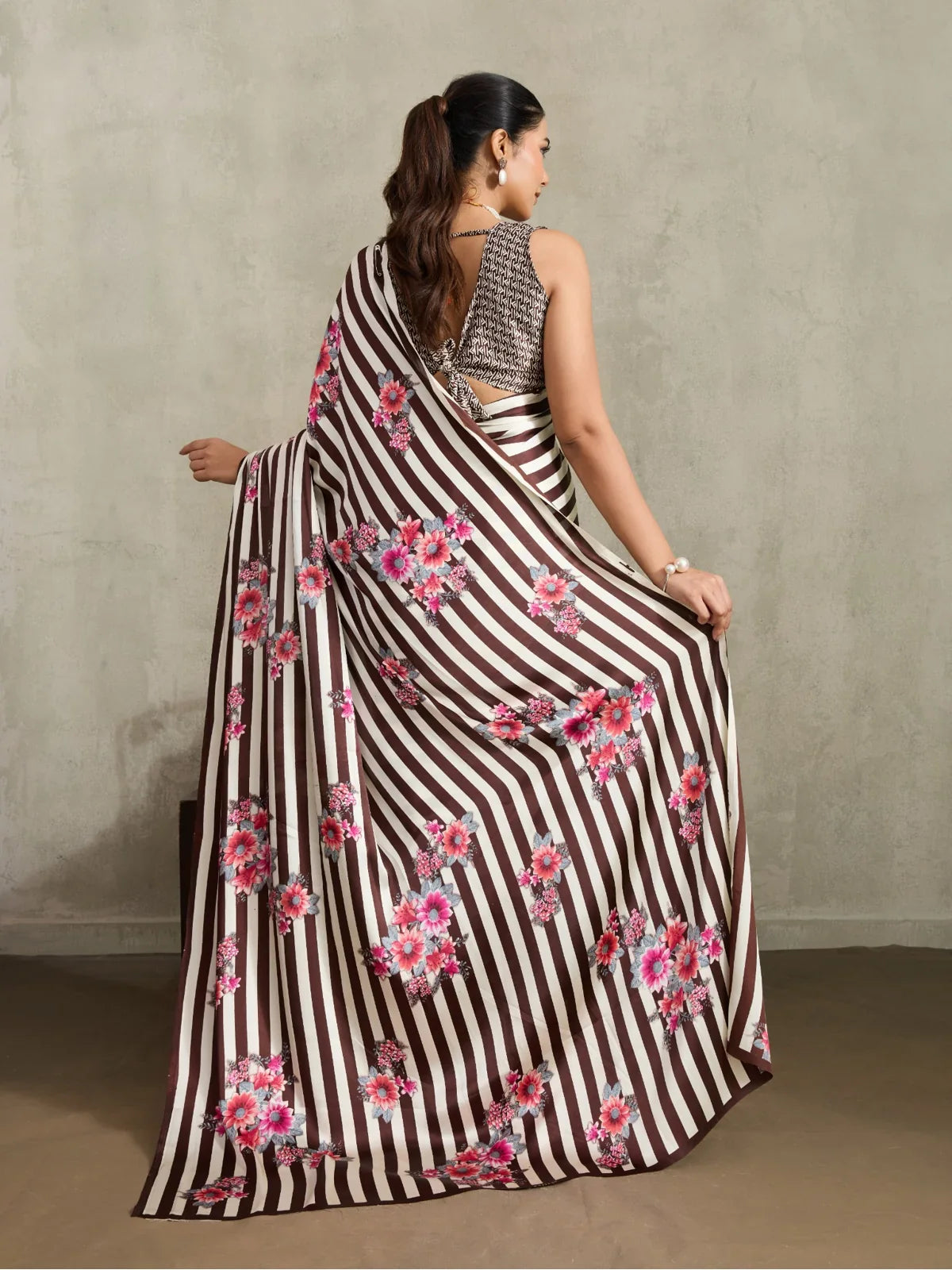 Tarani modal satin saree full back view showcasing floral pallu design and sleeveless blouse style