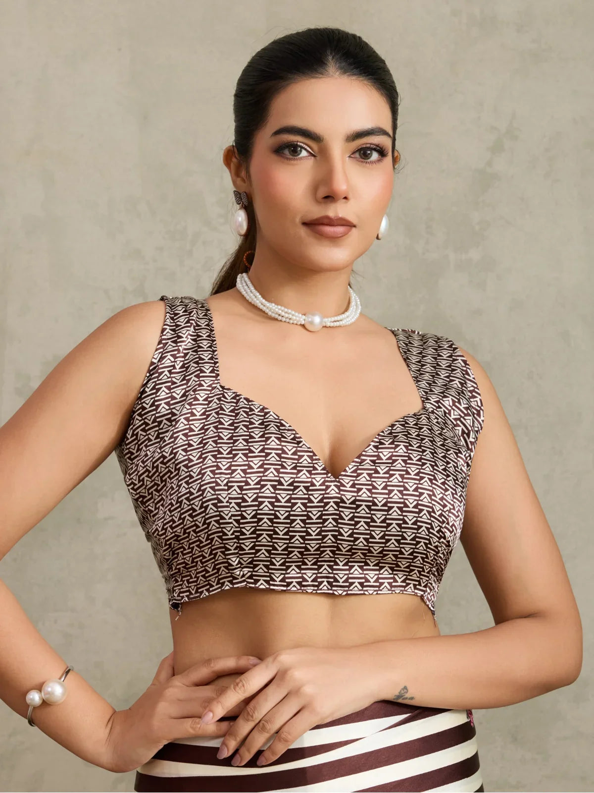 Tarani modal satin saree blouse close-up showing brown geometric pattern and deep neckline design