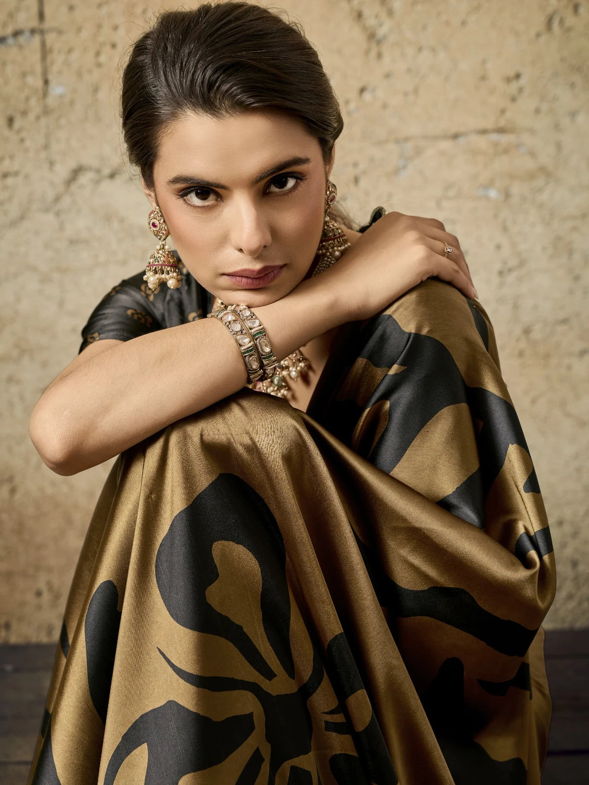 Tarani closeup view of brown modal satin Ajrakh print saree highlighting soft texture and elegant detailing