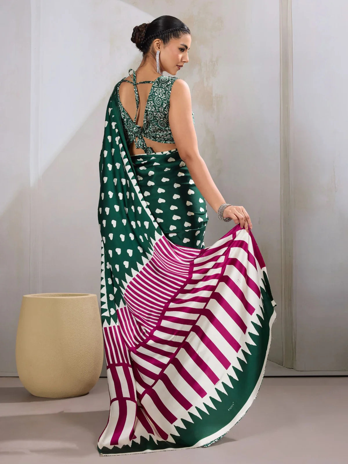 Tarani green saree with back pose highlighting criss-cross blouse tie-up and bold pallu pattern