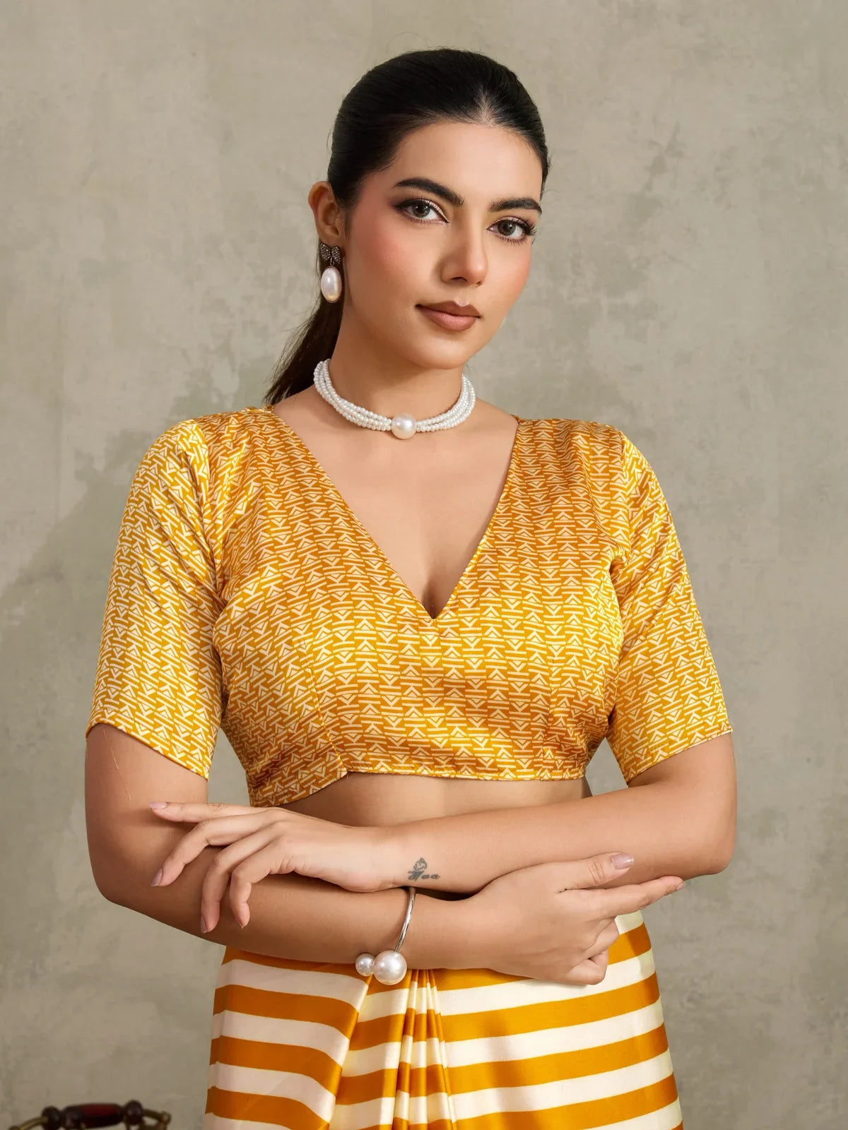 Tarani mustard blouse close-up with deep V-neck and intricate geometric print design in yellow