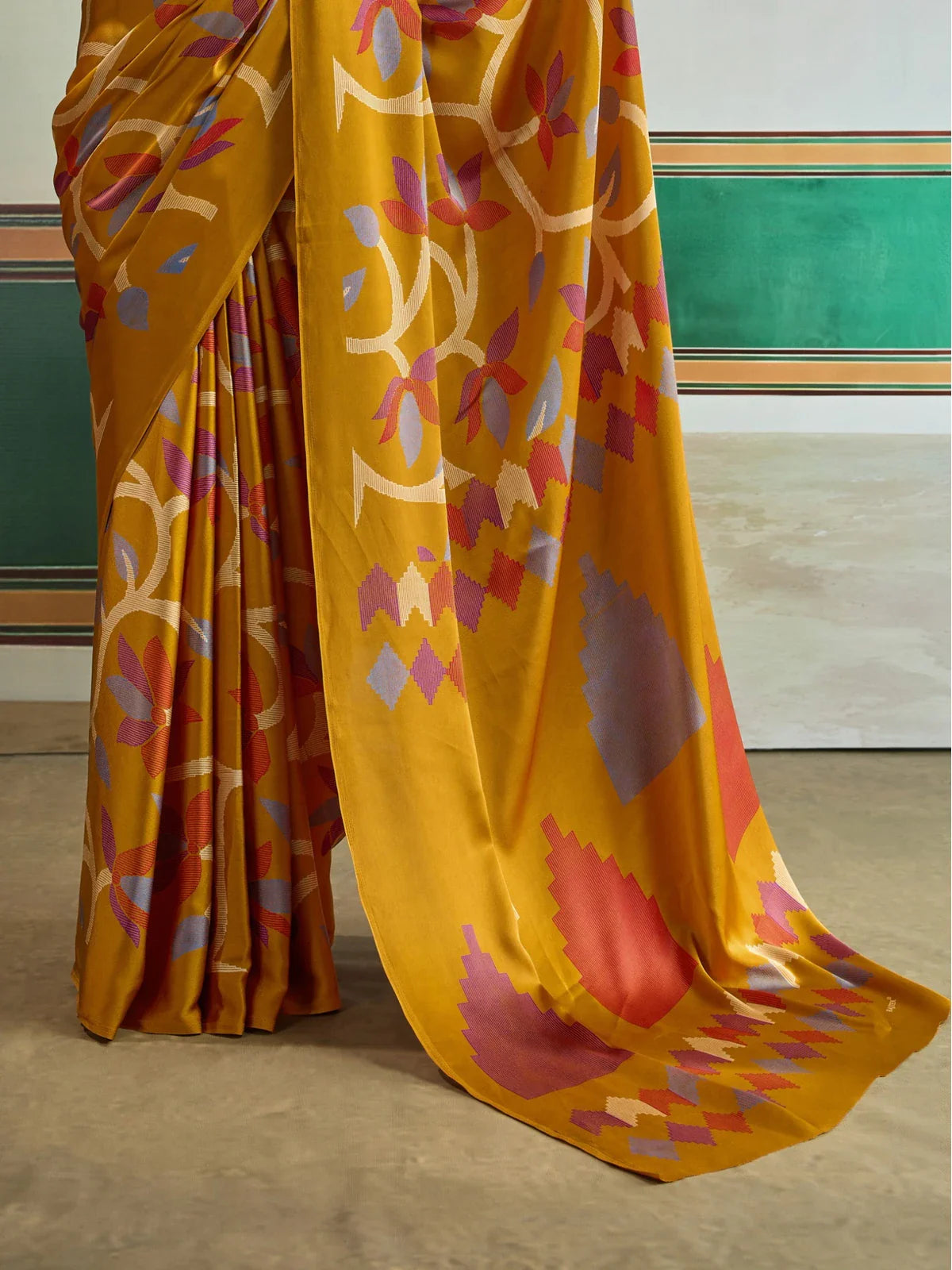 Tarani mustard Ajrakh saree pallu close-up with multicolor stepped motifs in red, purple, cream and blue shades