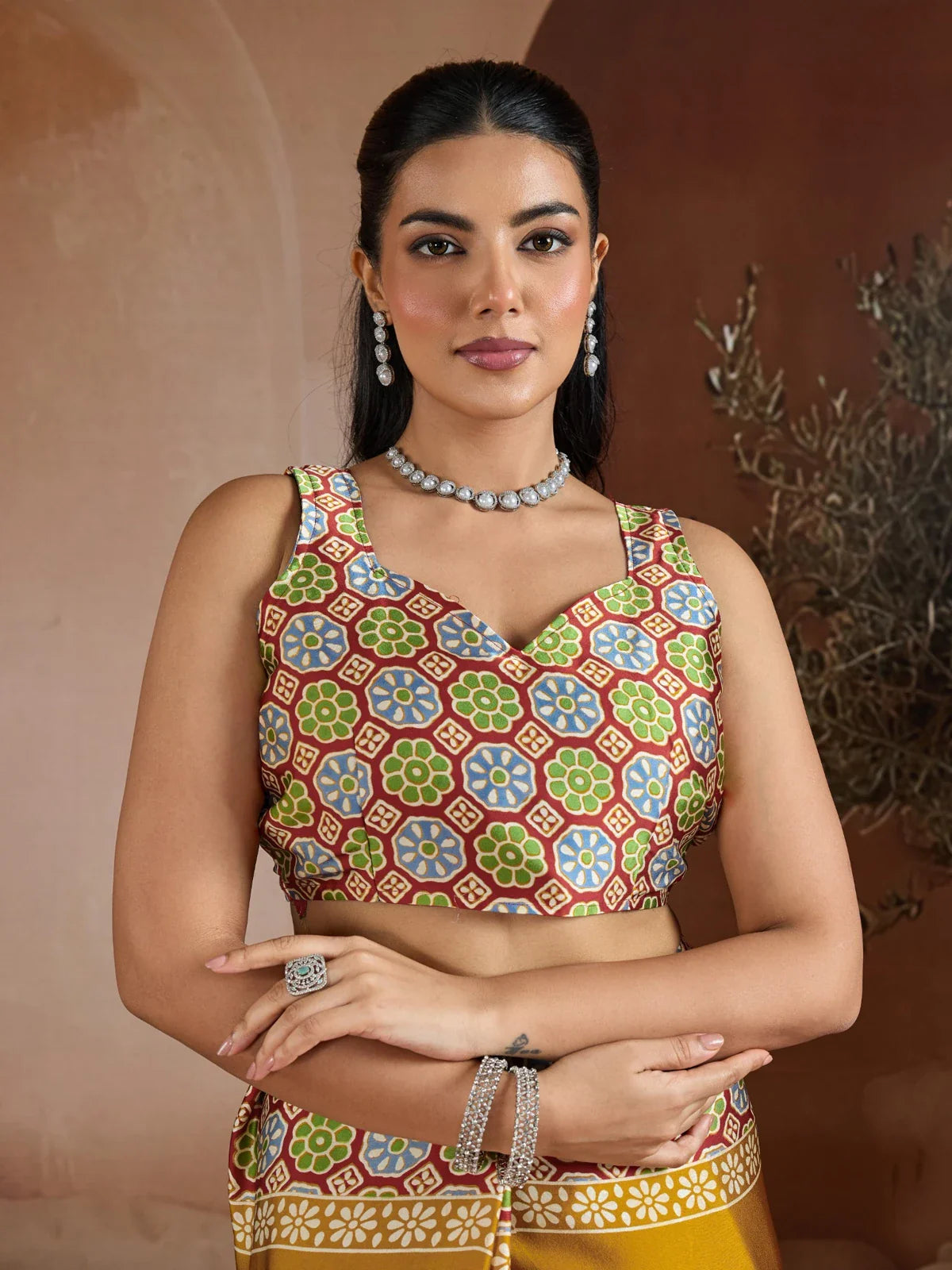 Tarani mustard modal satin saree upper body view showcasing sleeveless printed blouse and jewellery