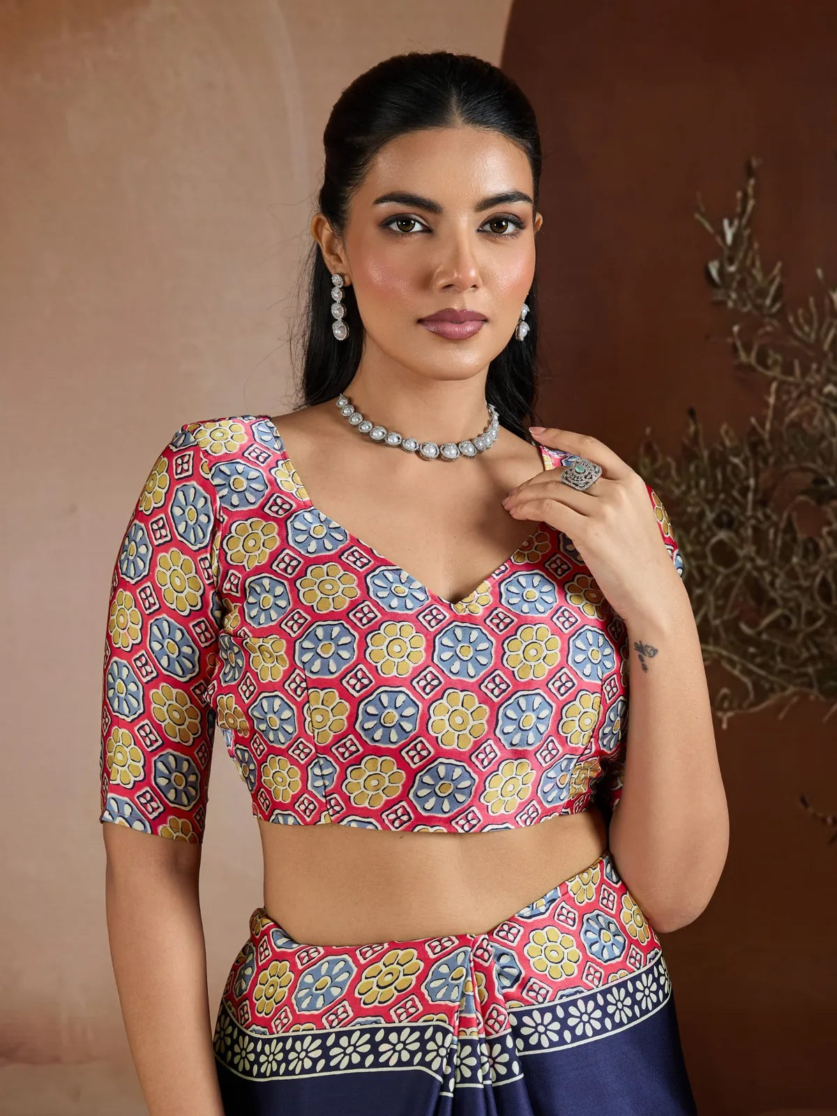 Tarani designer blouse in red, yellow, and blue floral print paired with navy blue saree in modal satin