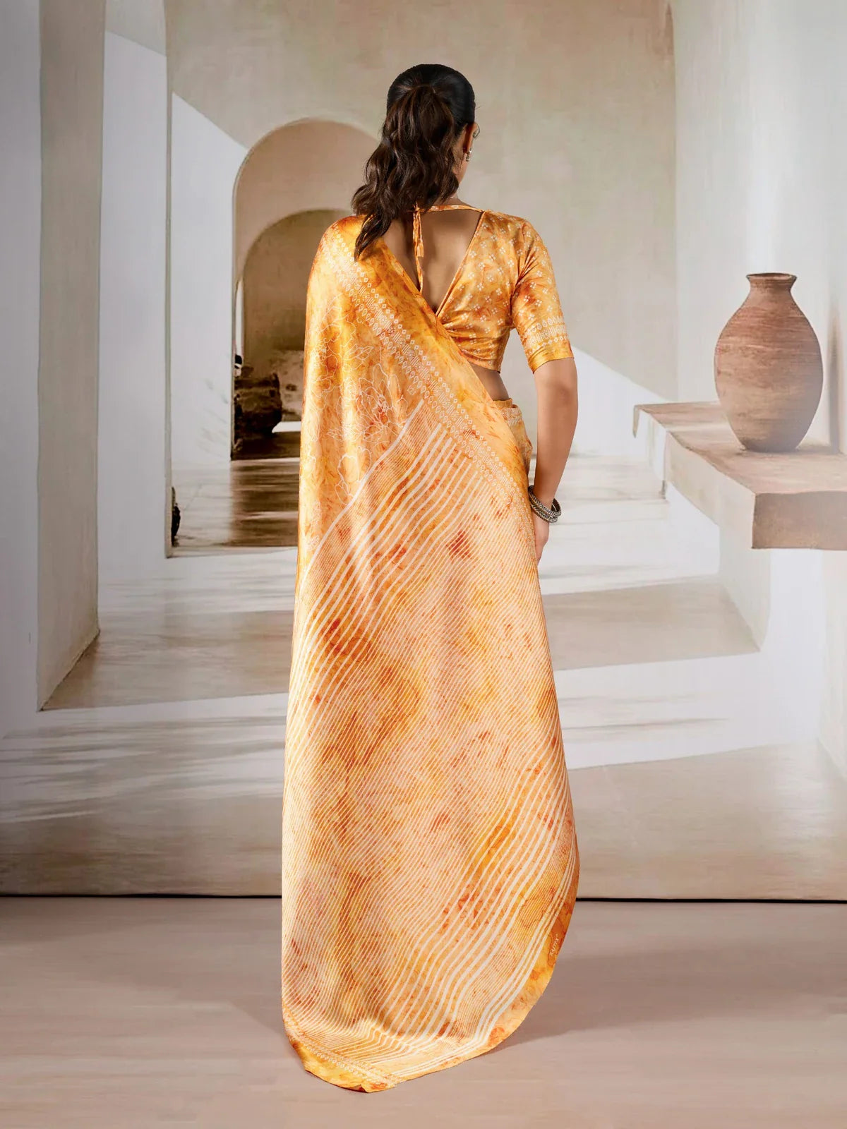 Tarani orange saree model back view showing the tie-back blouse and soft saree drape