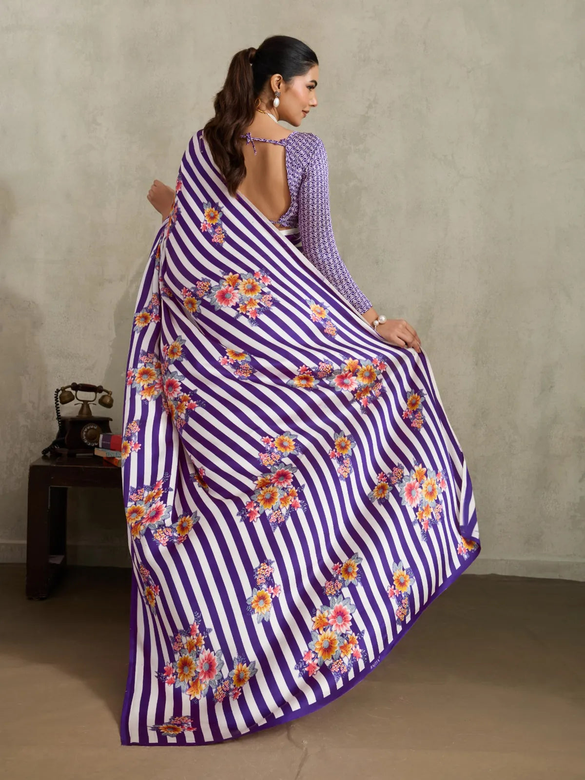 Tarani purple saree back view featuring floral pallu drape and open back blouse in elegant satin texture