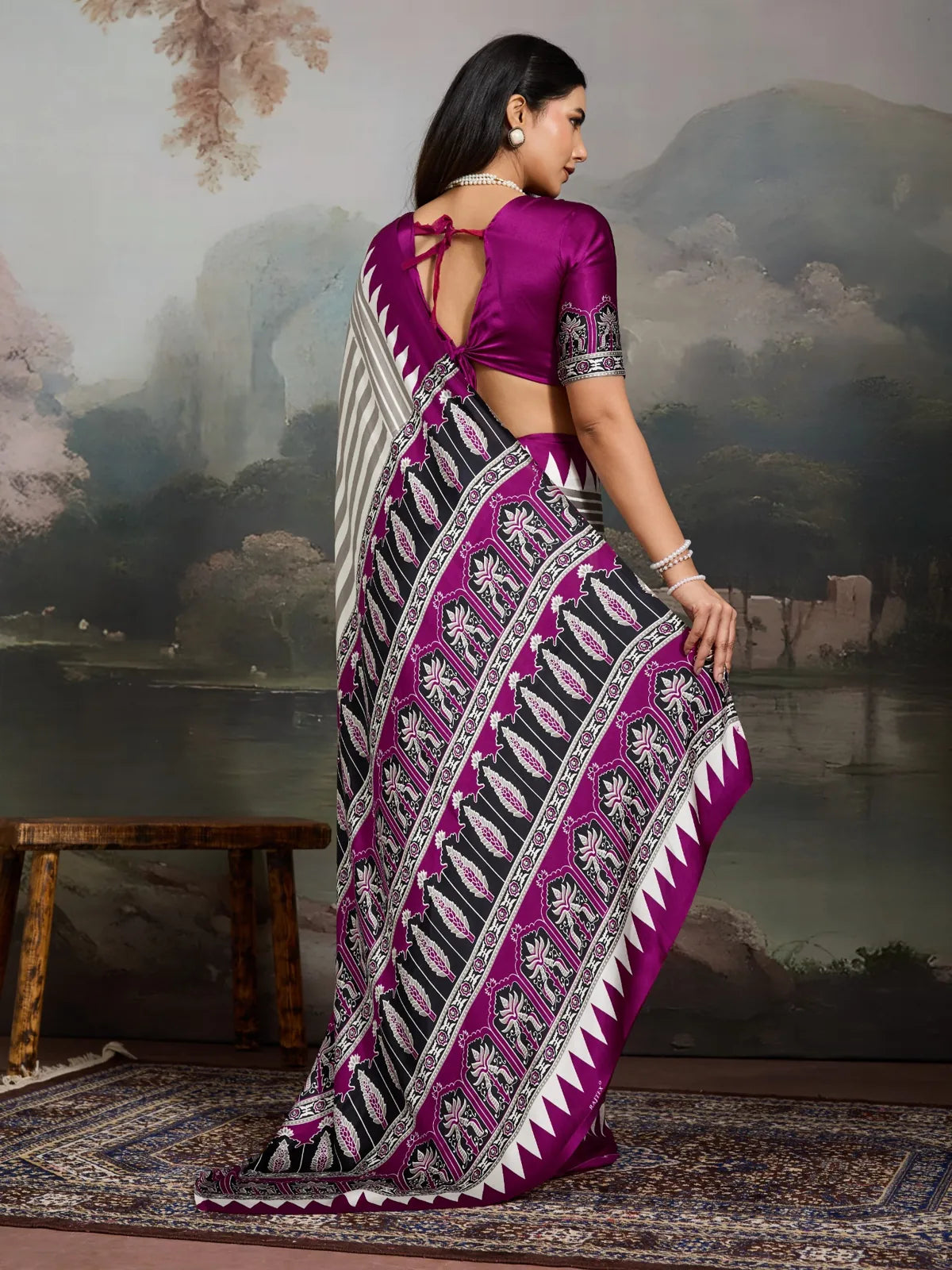 Tarani back view of model wearing purple modal satin ajrakh saree with printed pallu and tie-up blouse