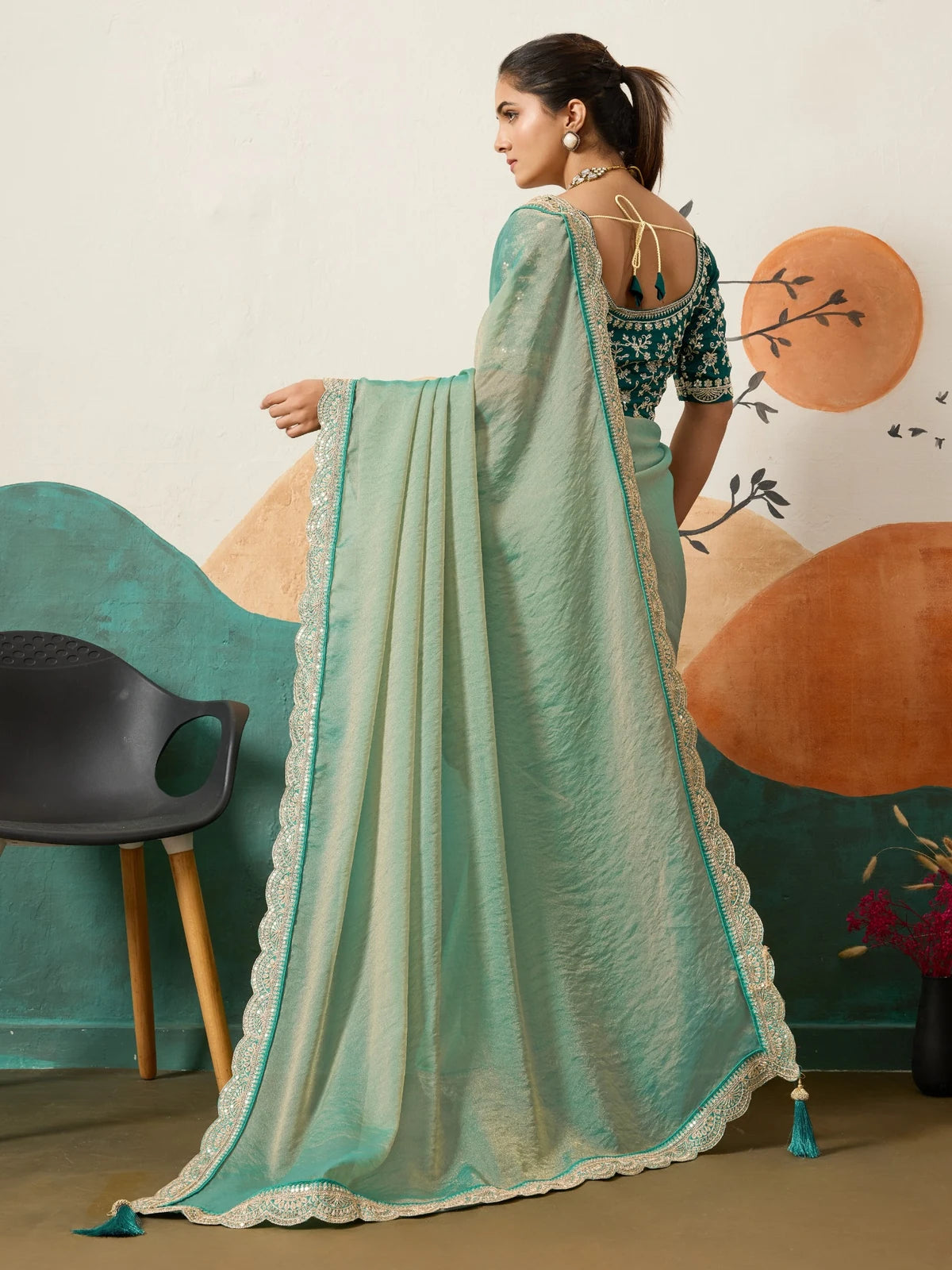 Tarani sea green saree back view with stylish blouse pattern and tassel details