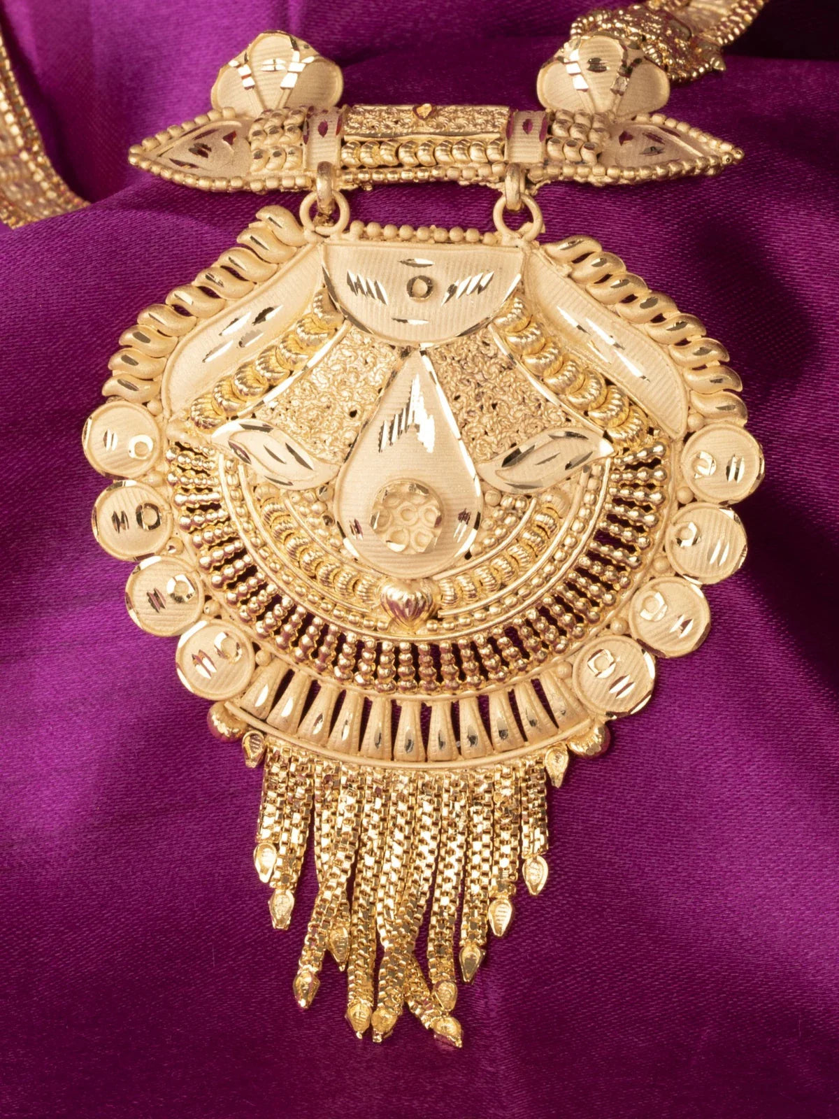 Tarani closeup of gold plated necklace pendant with detailed design for weddings