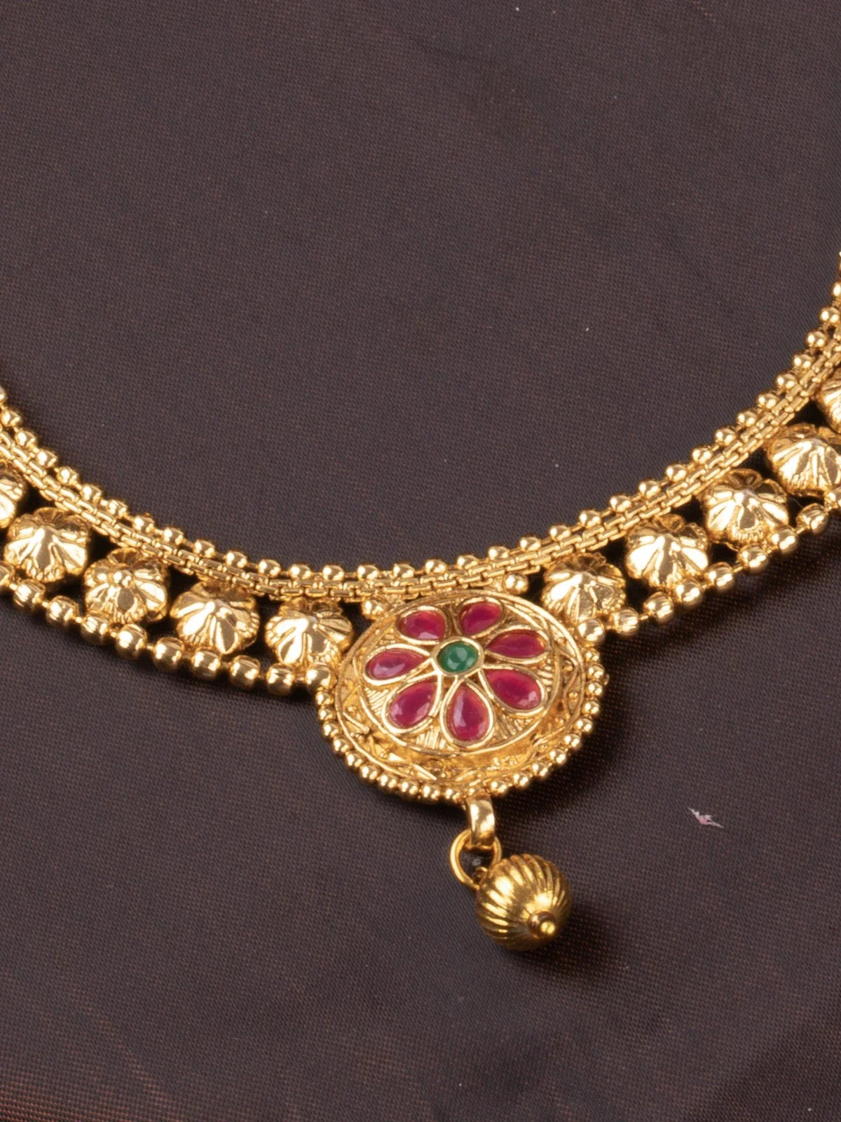 Tarani closeup of gold plated necklace set showing stone studded detailing for festive wear
